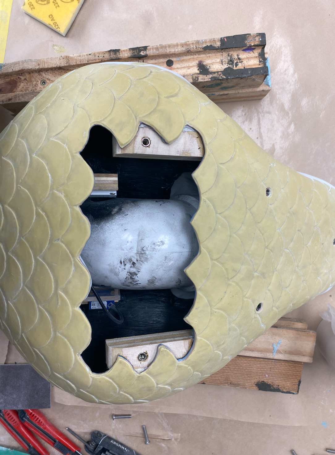 Materials: West System 105 Epoxy Resin, 204 Epoxy Hardener, Fiberglass Cloth, PVCElbow + Flange, Beam Break Sensor and Reflector, PVC Cement, Free Form Sculpt, Plywood, Zap-a-Gap Superglue, Threaded inserts, Plexiglass, Pneumatic Hose, Zoopoxy Dough