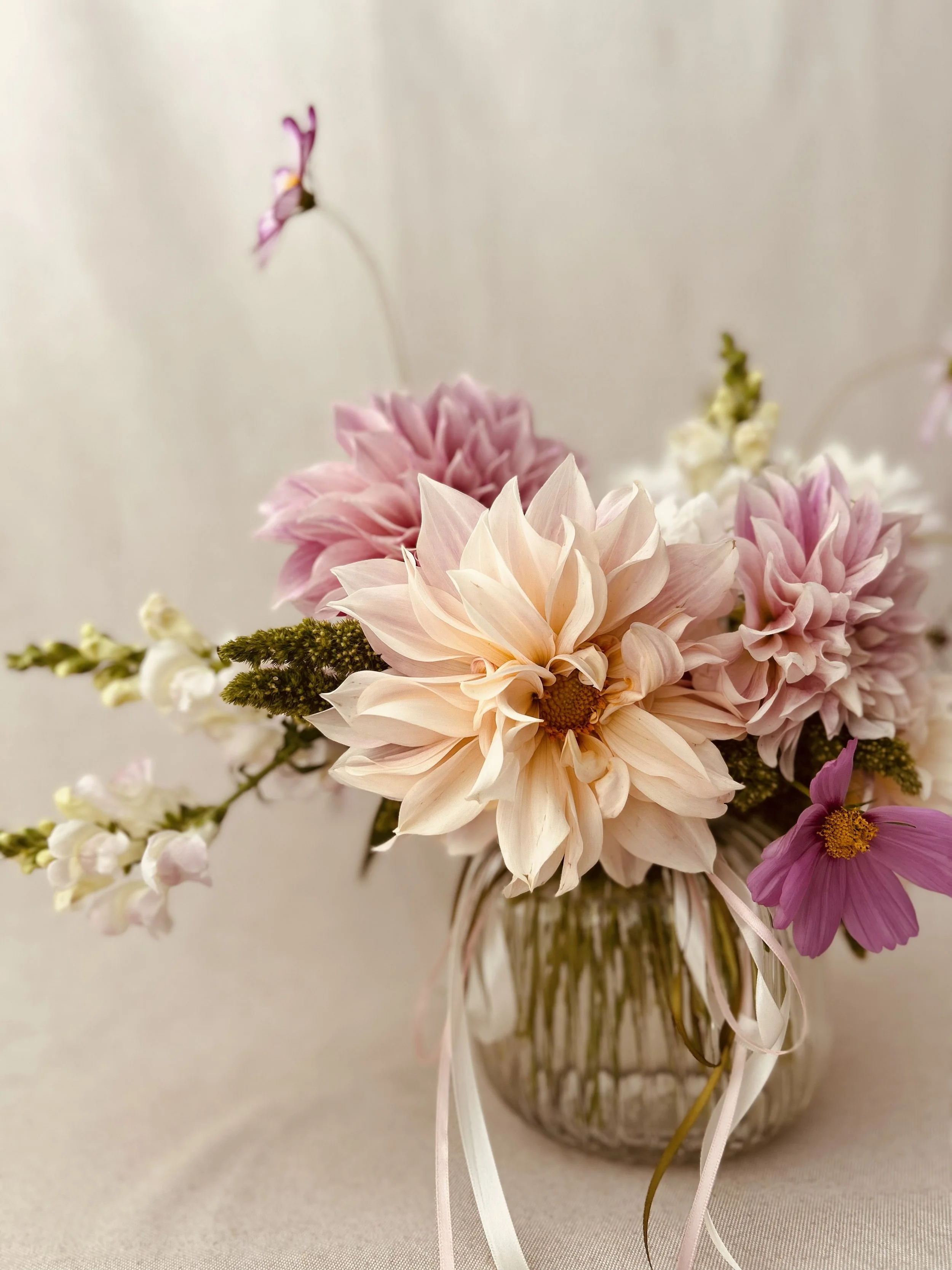 A bouquet of pink, white, and purple flowers in a glass vase.