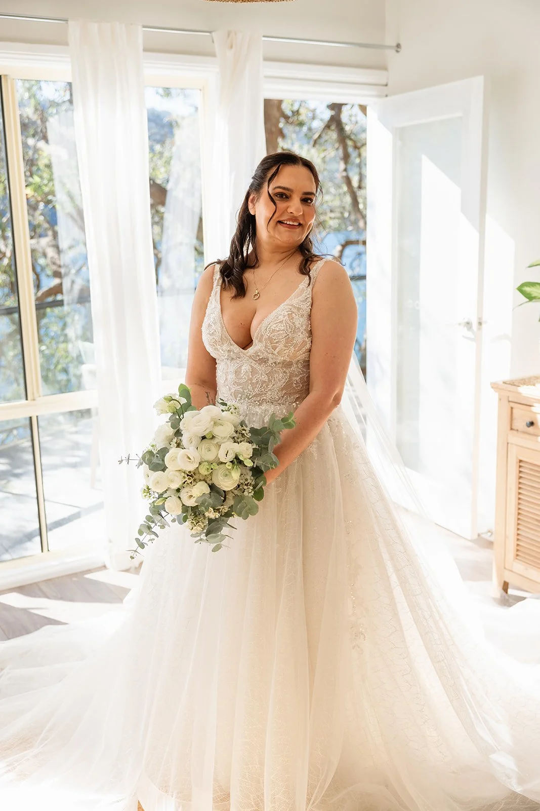 bride in white dress holding white wedding bouquet