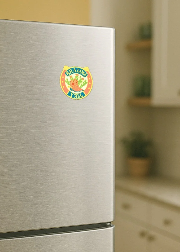 Jewish-themed magnet featuring cowboy boots decorated with pomegranates and a horseshoe above the words “Shalom Y’all.” Measures 3 by 3.1 inches.