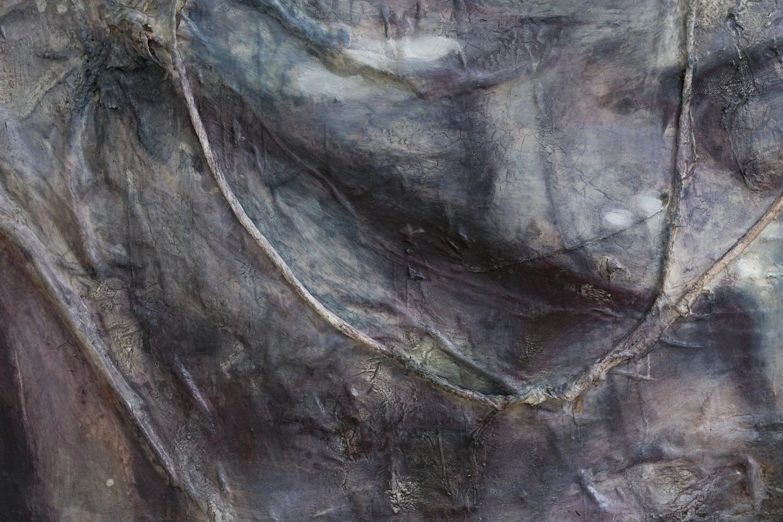 Close-up of a textured, rocky surface of a painting with various shades of gray, brown, and hints of purple, showing encaustic formations.