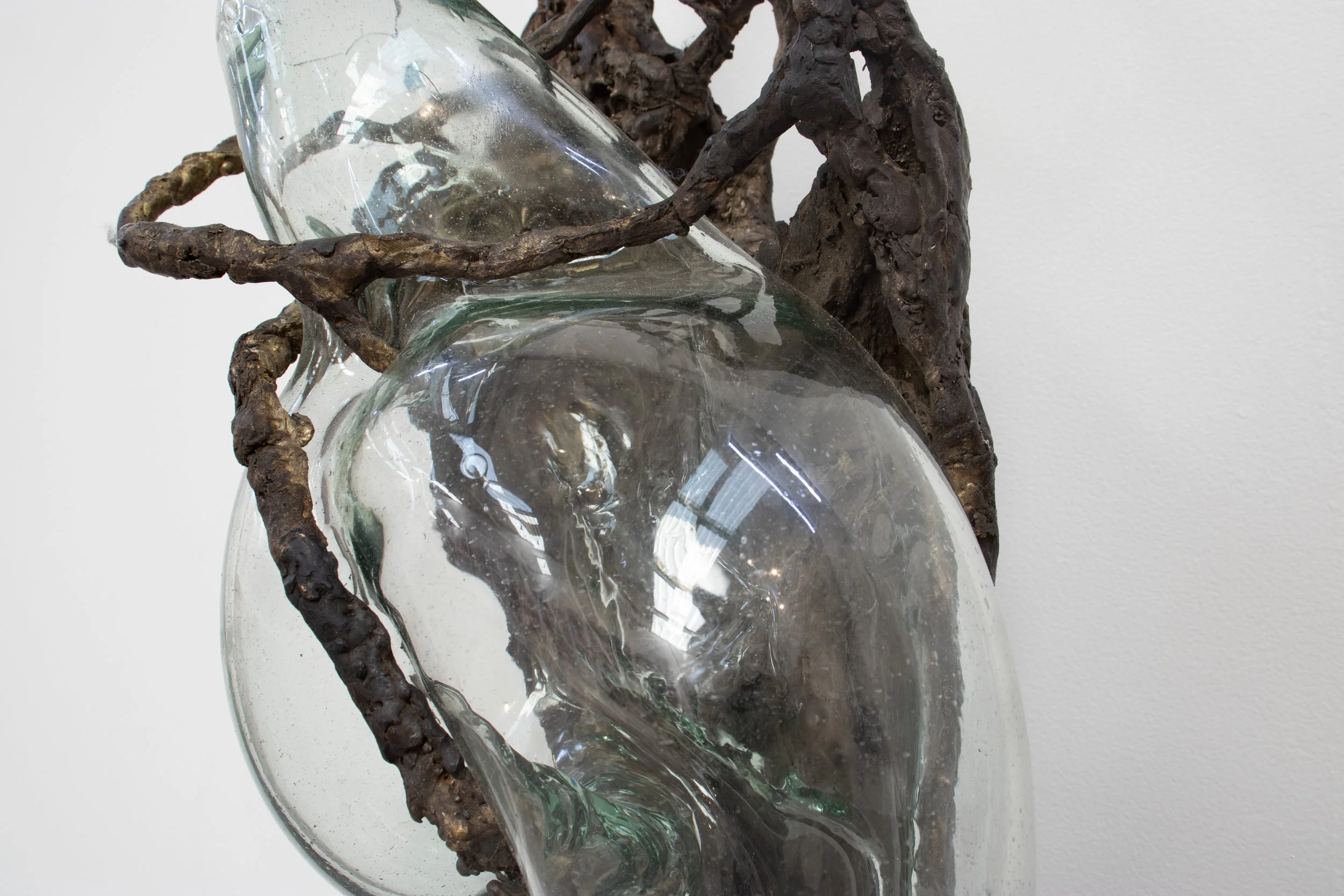 Close-up of a glass vase with twisted metal wire inside it, set against a plain white background.