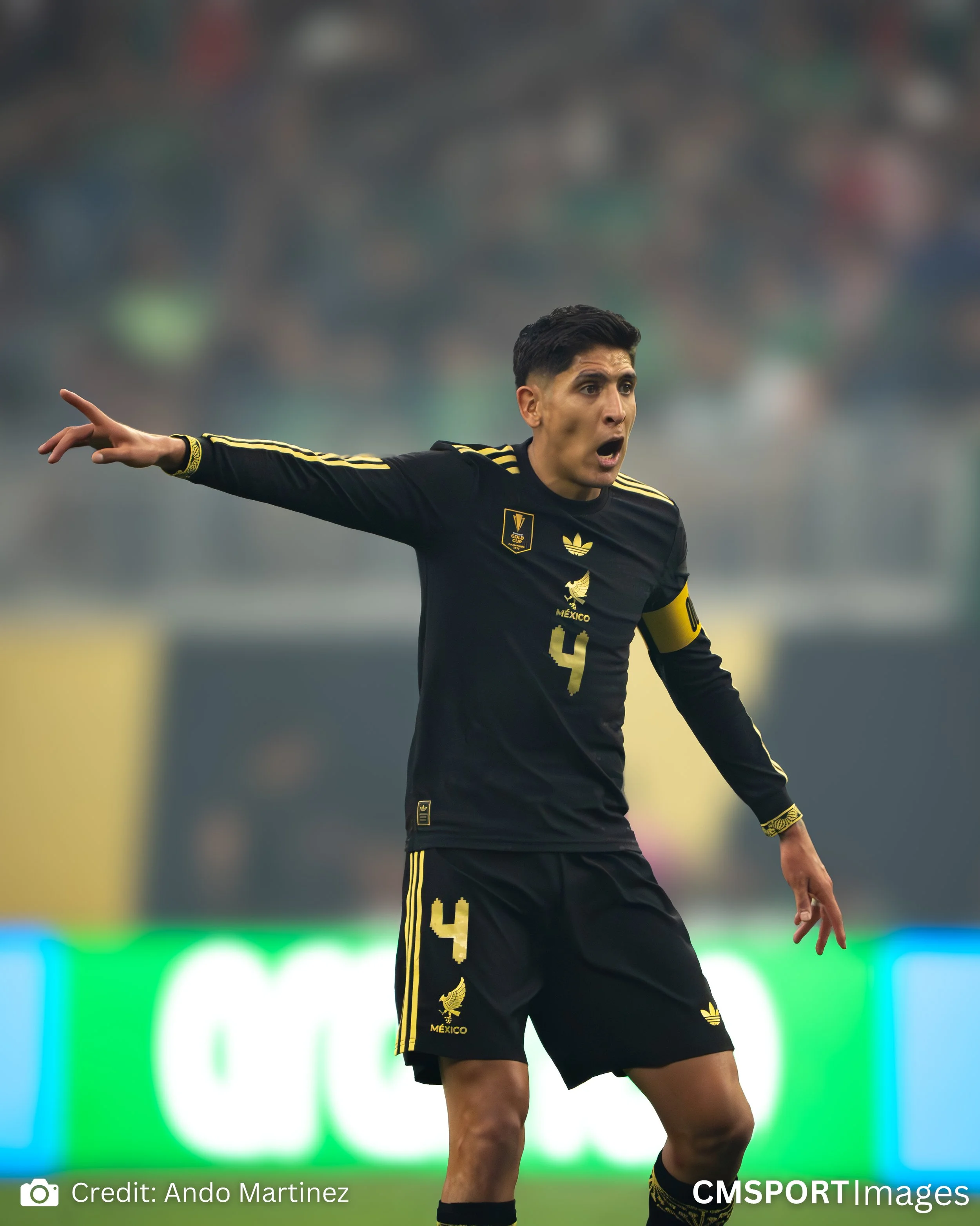 A soccer player in a black and gold uniform with the number 4, passionately gesturing during a match on the field.