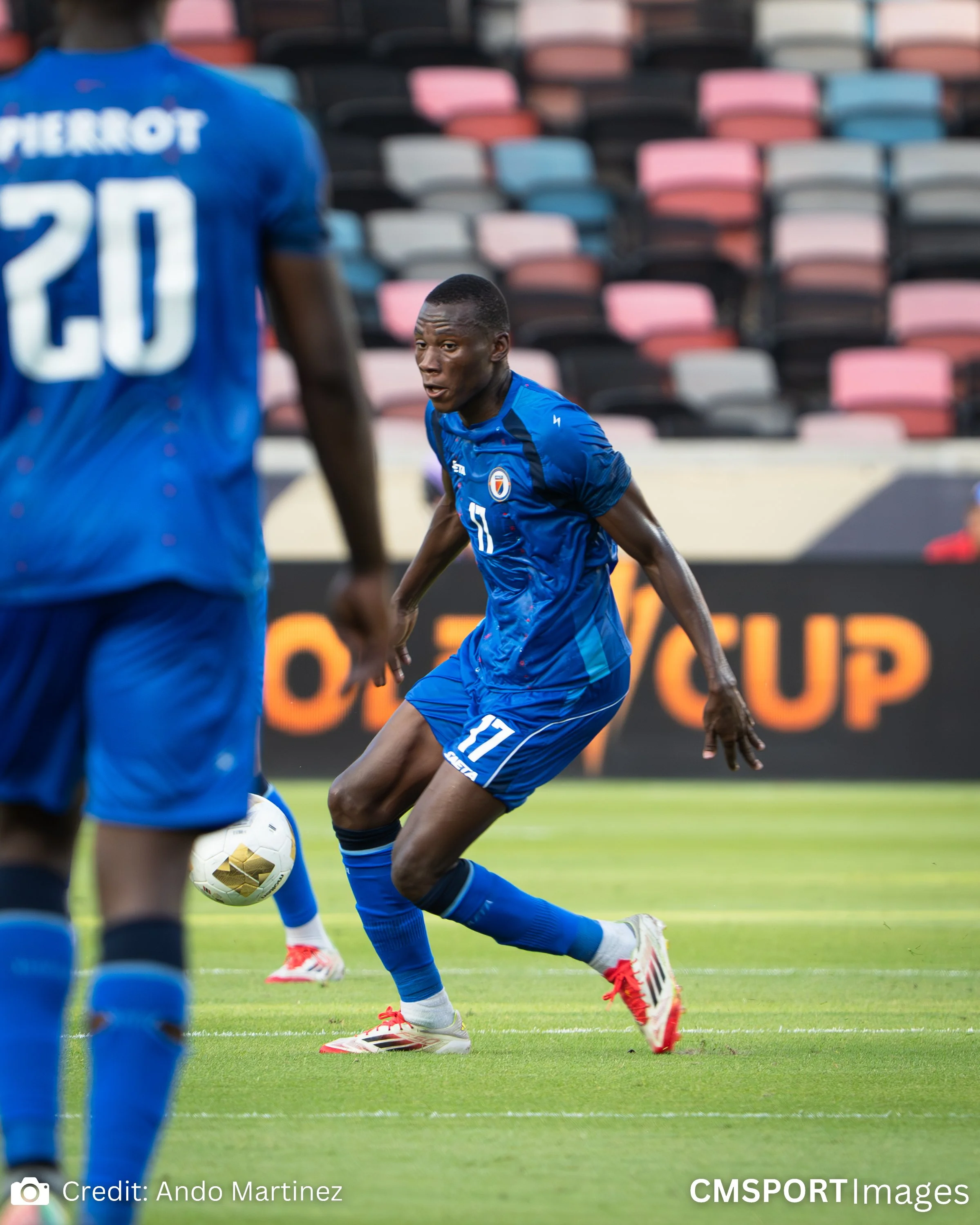 Soccer players in blue uniforms on a field during a match.