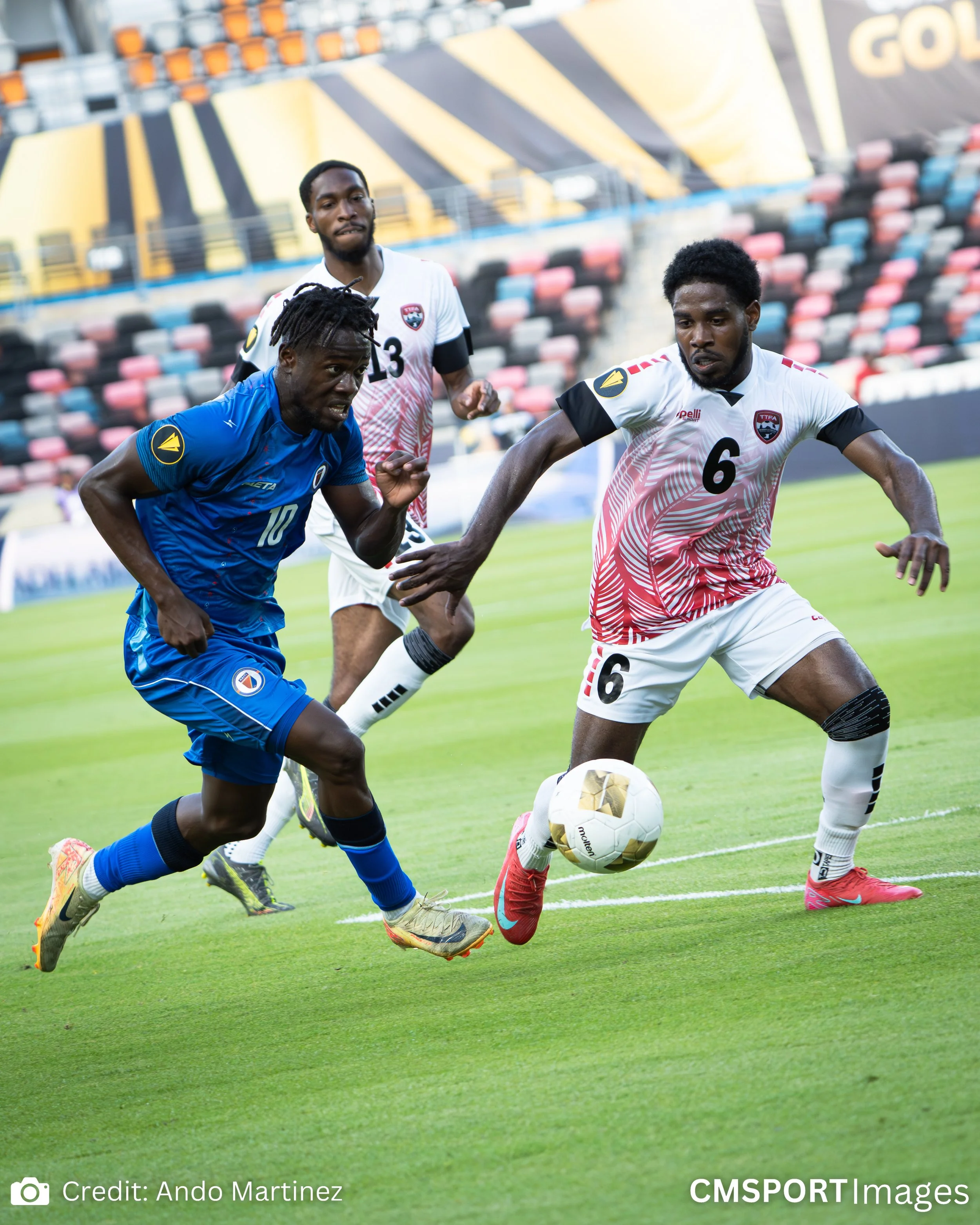 Soccer players in a match competing for the ball on the field.