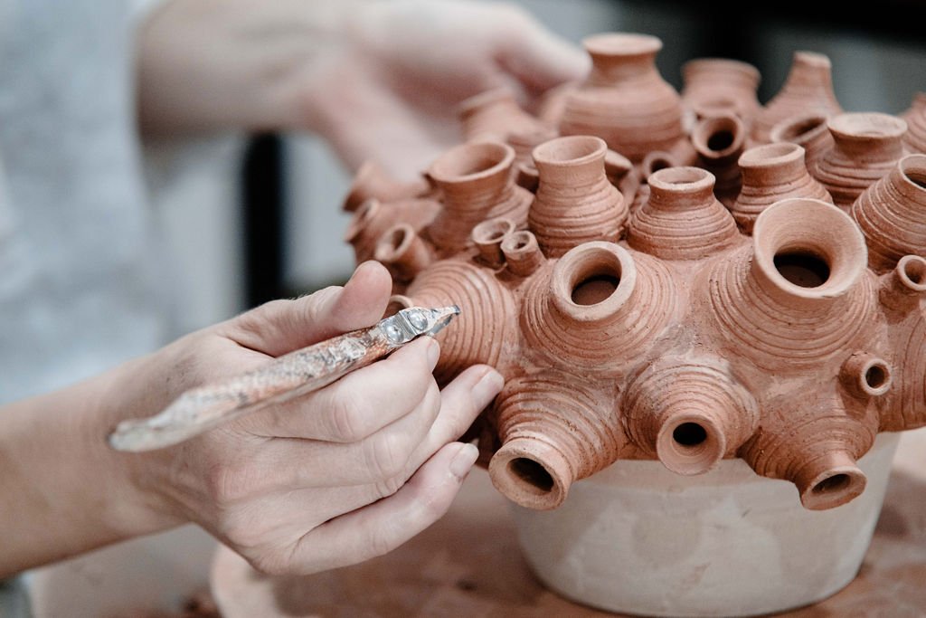 Hands of Jude Muduioa, working on a sculpture for a woodfiring early 2025. I am using Raku T for this particular work. I like to use repetition and componentry to create my sculptural pieces