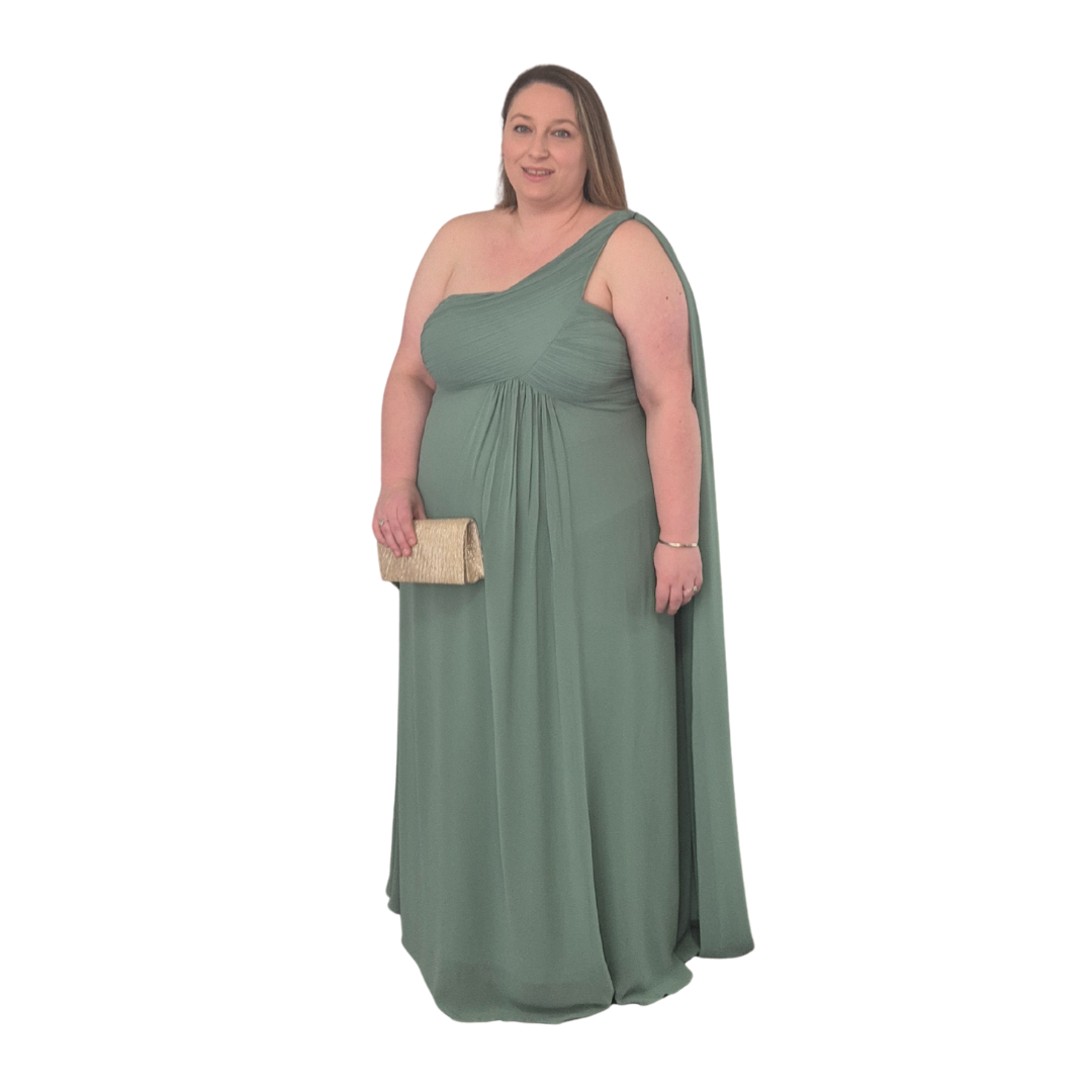 Teresa is wearing the size 22 in this stunning Tara design in Sage, the flow from the shoulder swooping down into the bust creates an elegant line. Extra train hanging from one shoulder giving that formal look. Pair with a trendy gold clutch for that