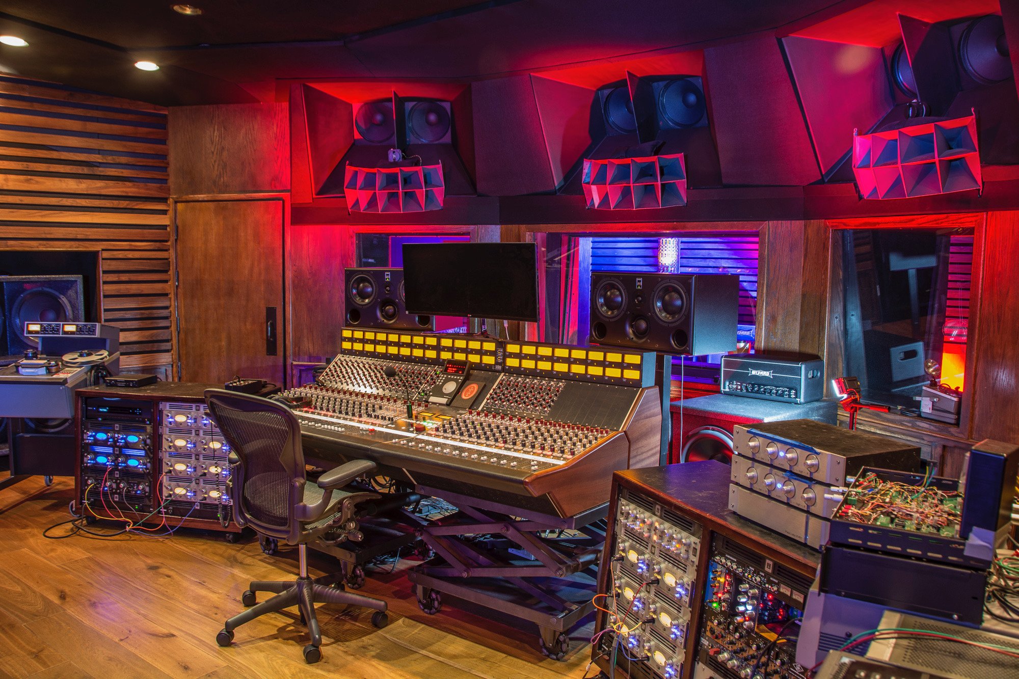 Professional Hollywood recording studio control room with mixing console, monitors and equipment racks.