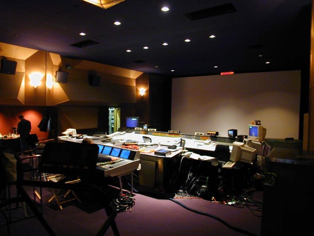 Professional audio mix stage with picture screen and large-format console.