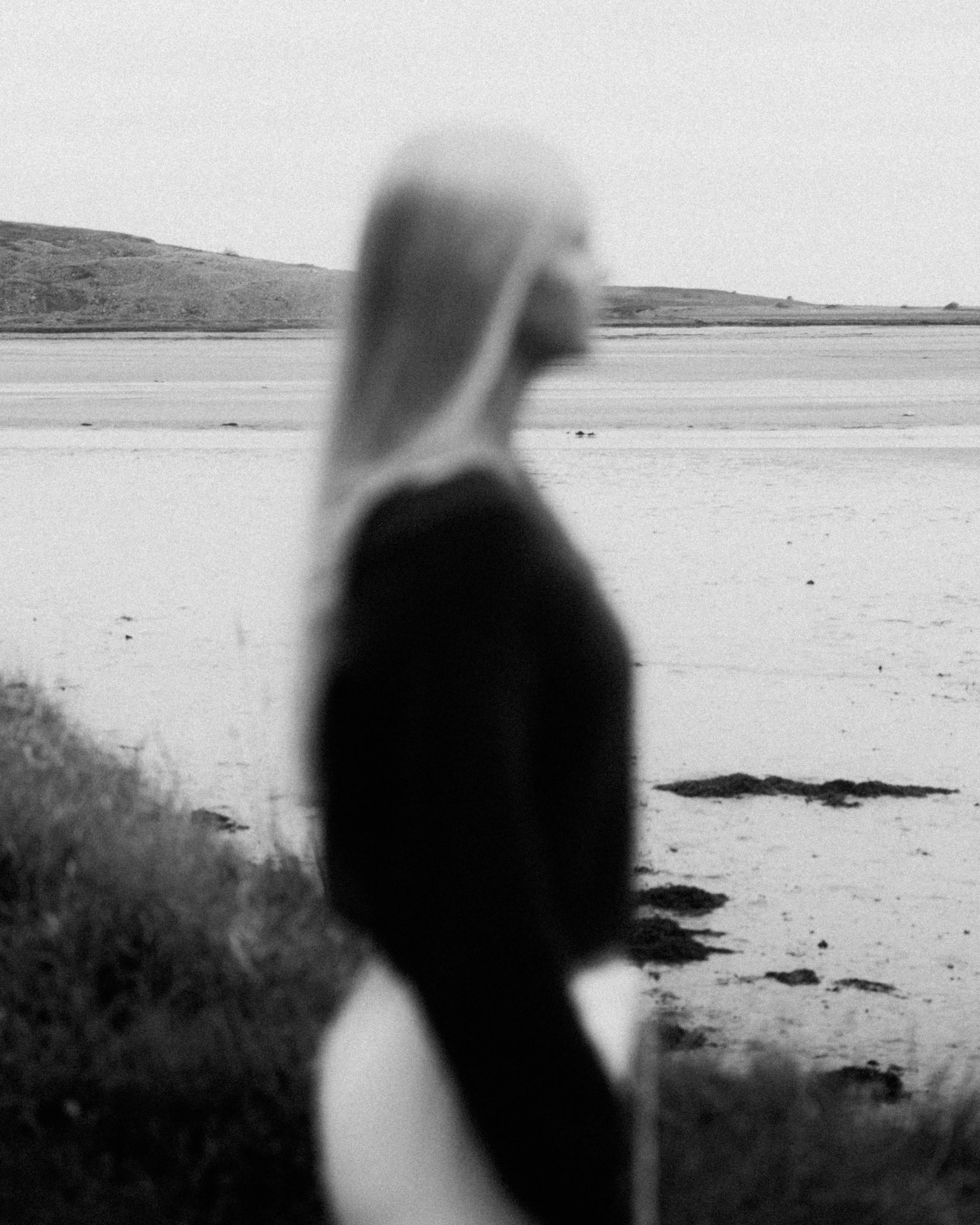 A black and white photo of Laura Ann Costello standing front of a lake in Galway.
