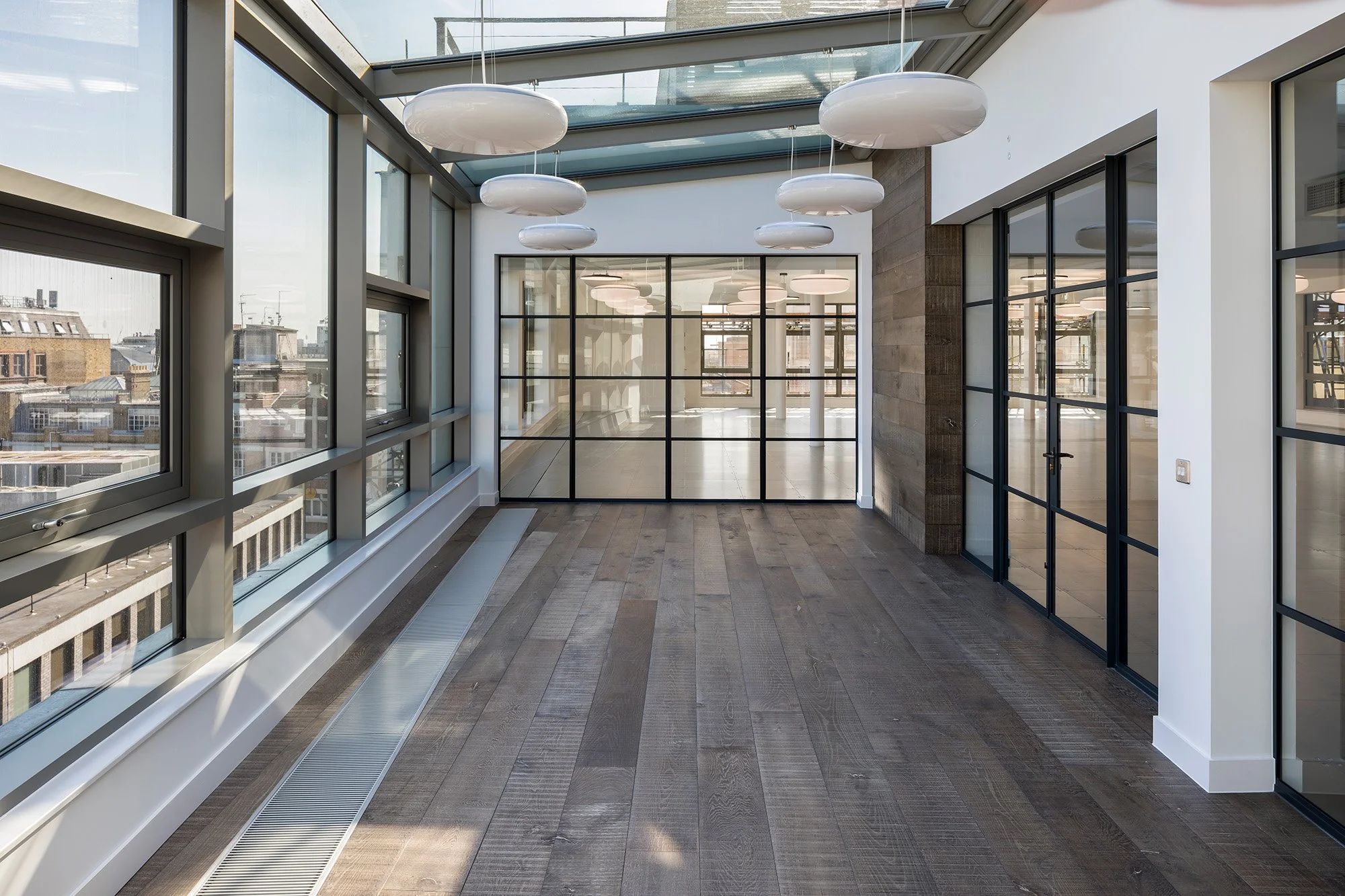 Completed contemporary office refurbishment with glazed meeting rooms, timber flooring and natural light