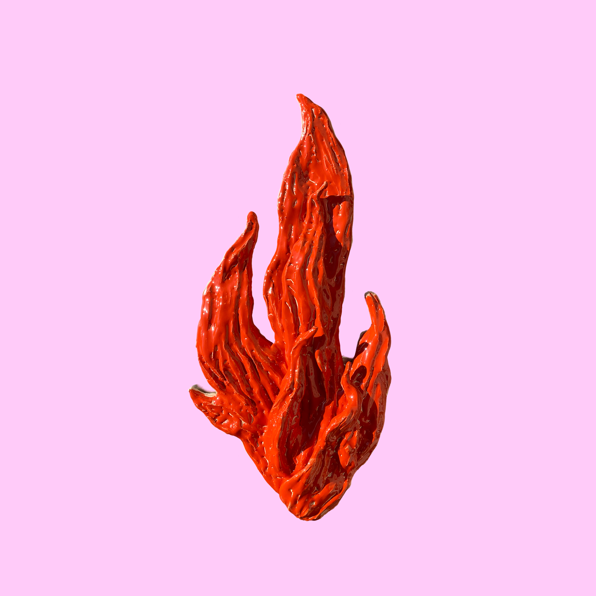 Rød flamme fremstillet i glaseret keramik på en lyserød baggrund.