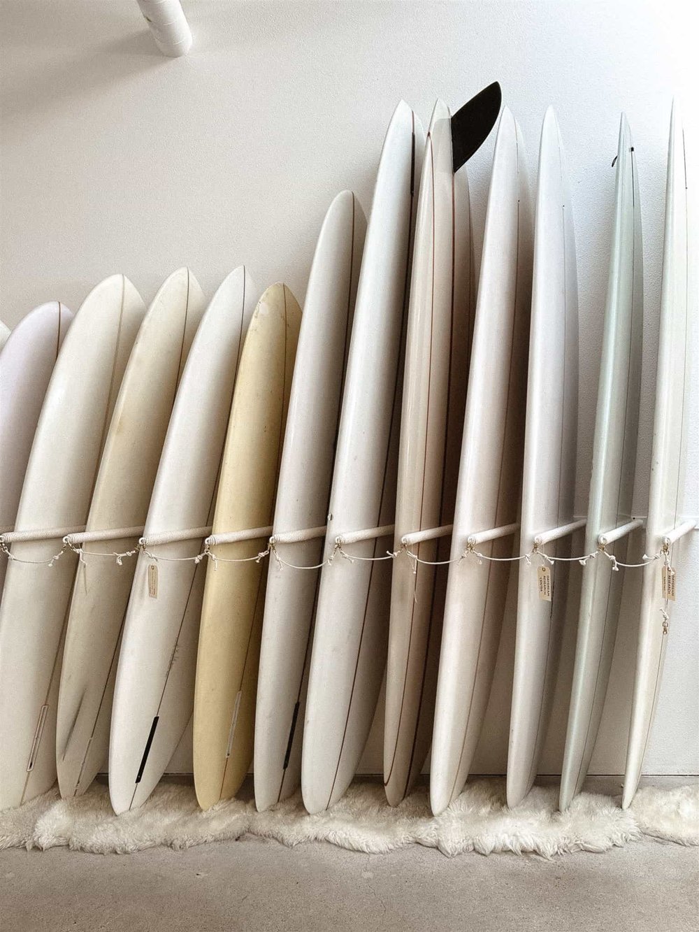 A row of neutral surfboards stacked upright