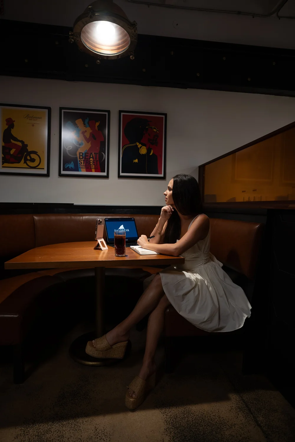 Daly working on a laptop at a restaurant booth