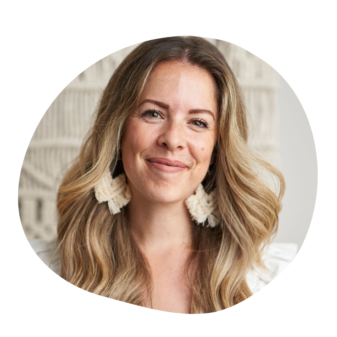 A woman smiling with long wavy blonde hair