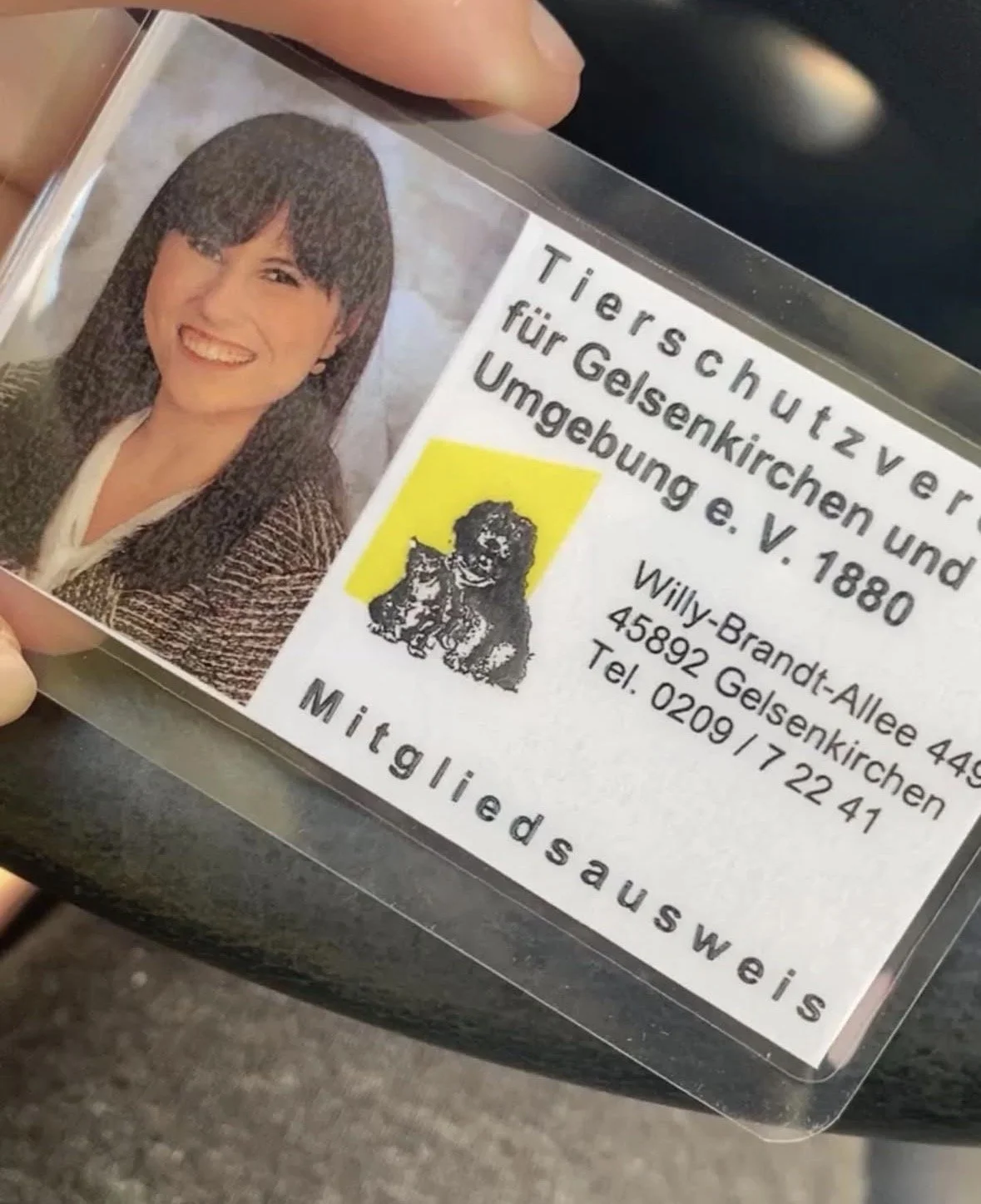Visitenkarte mit einem Foto einer lächelnden Frau, Text in Deutsch, Logo eines Hundes, Kontaktdaten, Hinweis auf Tierheim und Einrichtung.