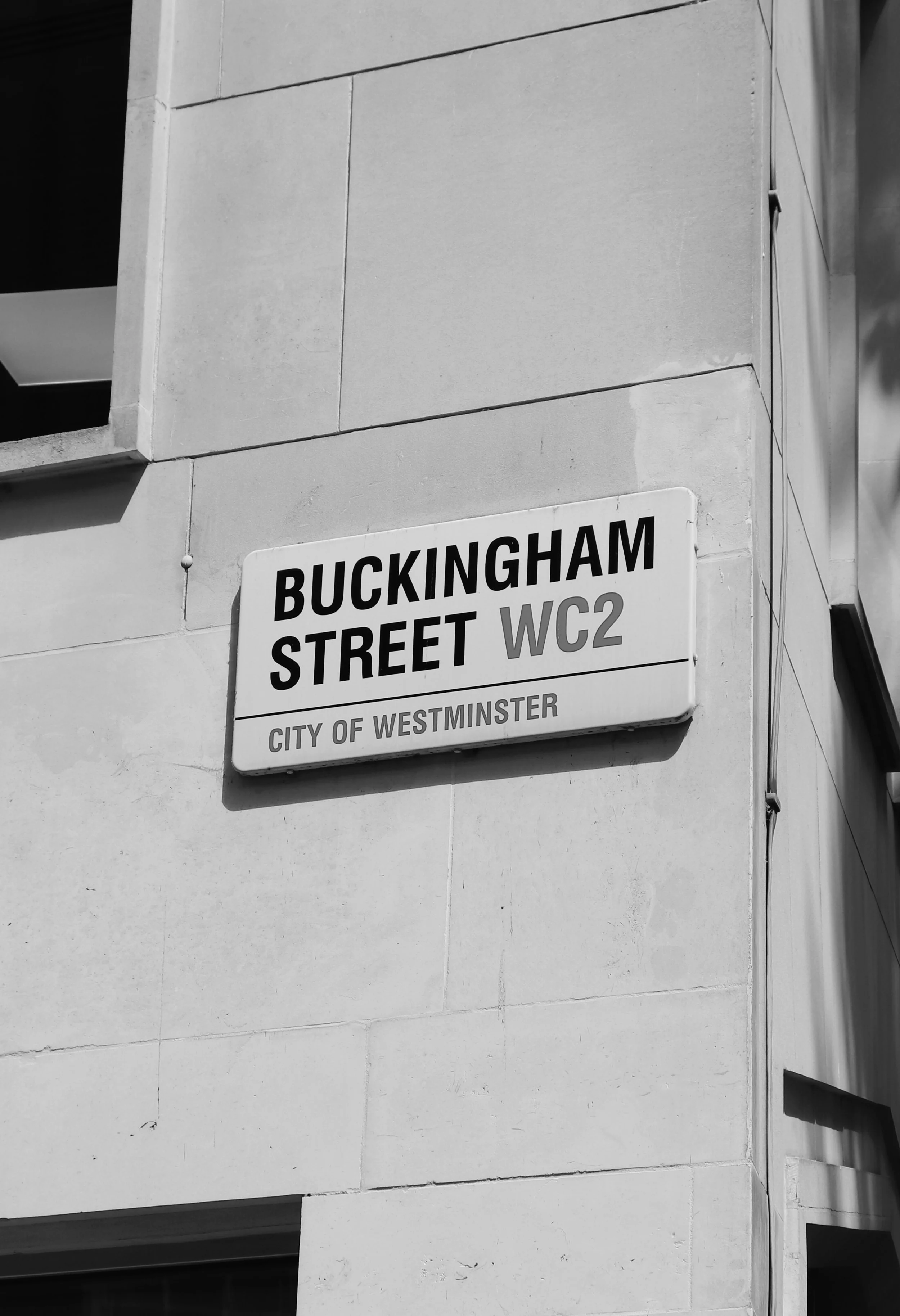 Street sign reading 'Buckingham Street WC2, City of Westminster' mounted on a building wall in Westminster, London.