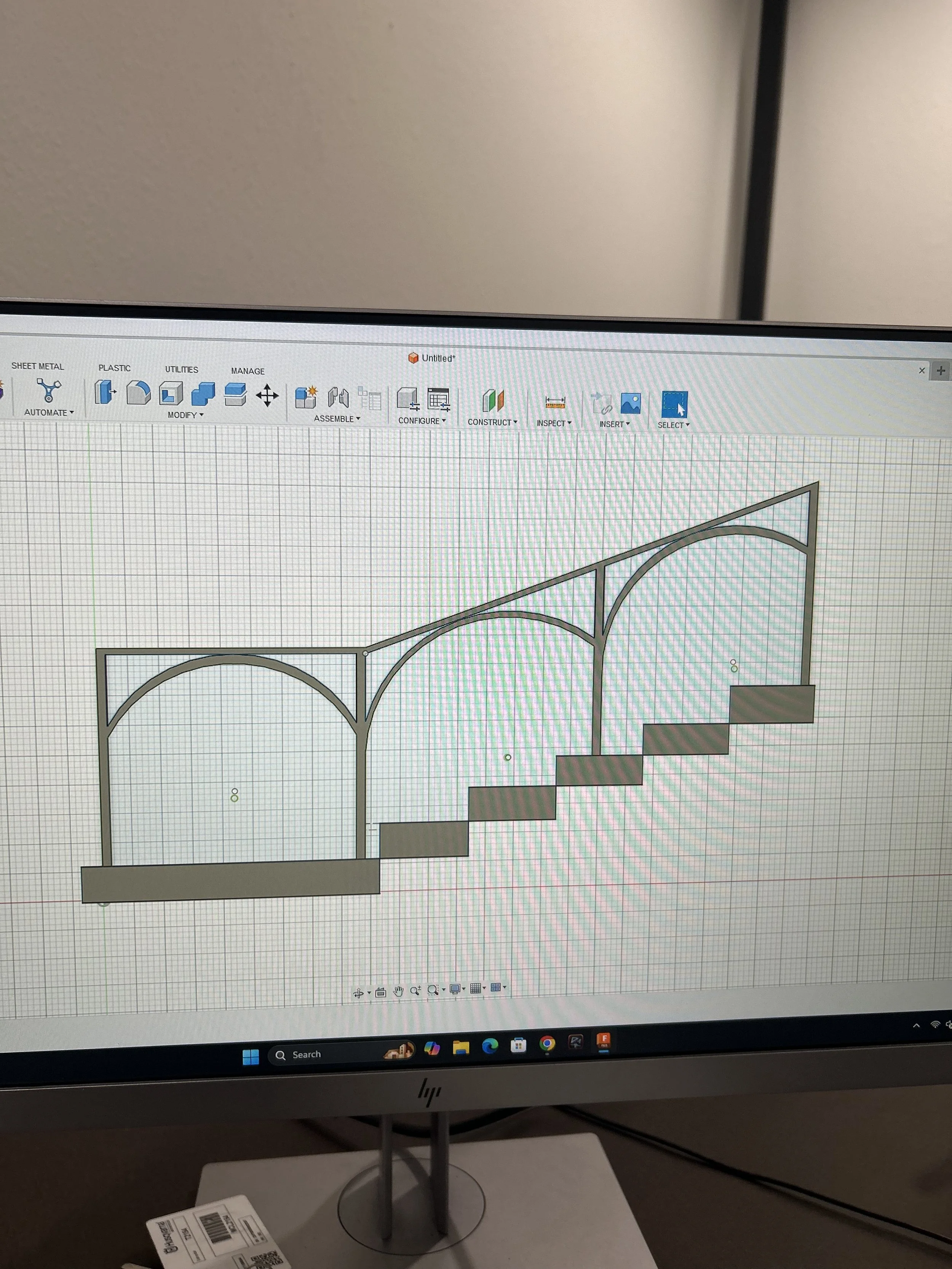 A computer screen displaying a CAD design of a decorative structure with arches and stairs.