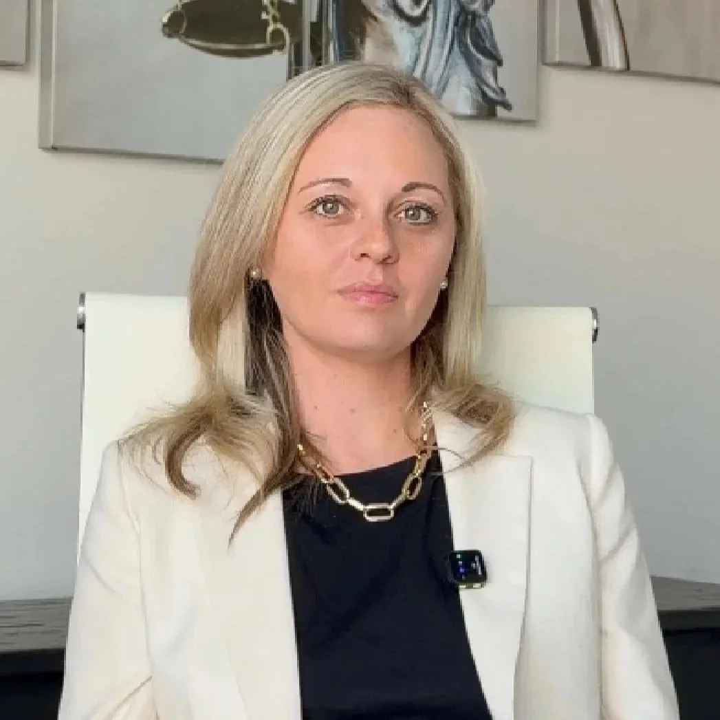 Confident blonde Manassas, VA defense attorney in cream suit.