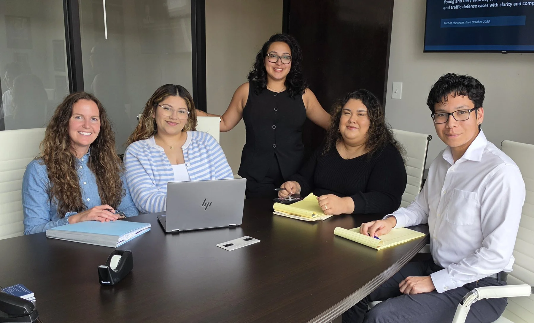 professional bilingual legal team sitting at a table smiling