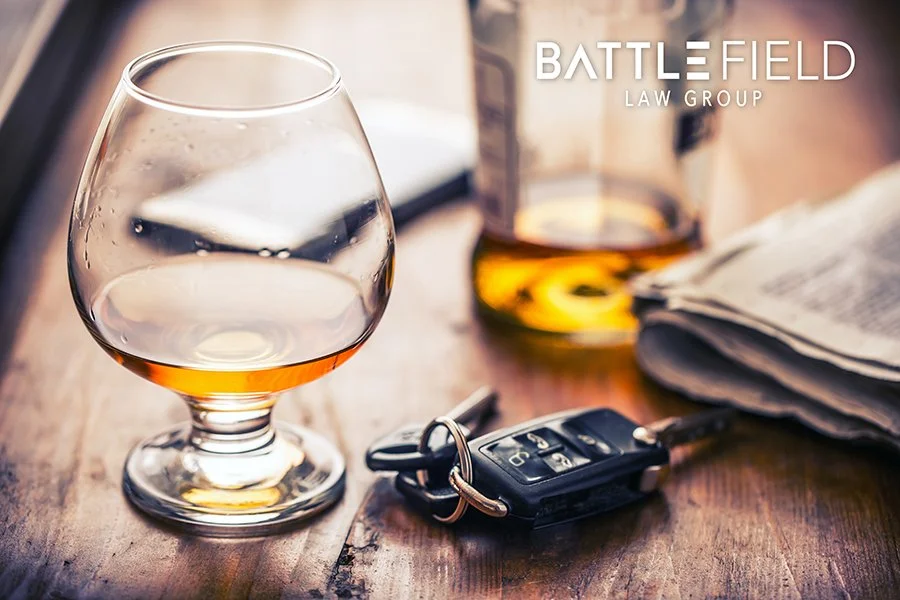 glasses filled with brown liquid on a wooden surface with car keys