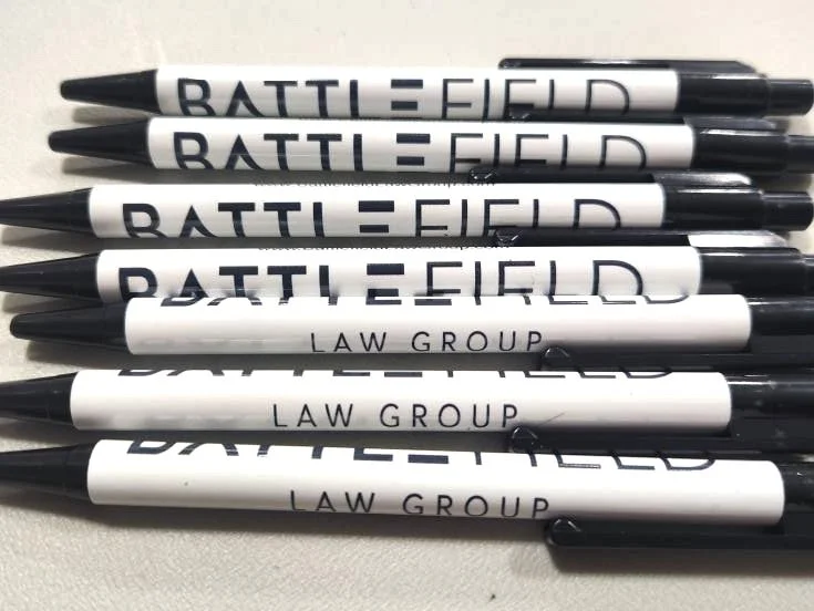 photo of a bunch of white and navy pens that say Battlefield Law Group