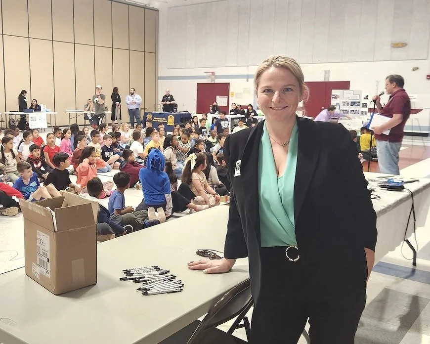 blonde professional criminal defense attorney at an elementary school auditorium for career day