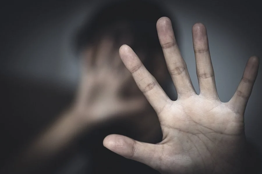 image of person with one hand on face and the other hand protectively pushed forward