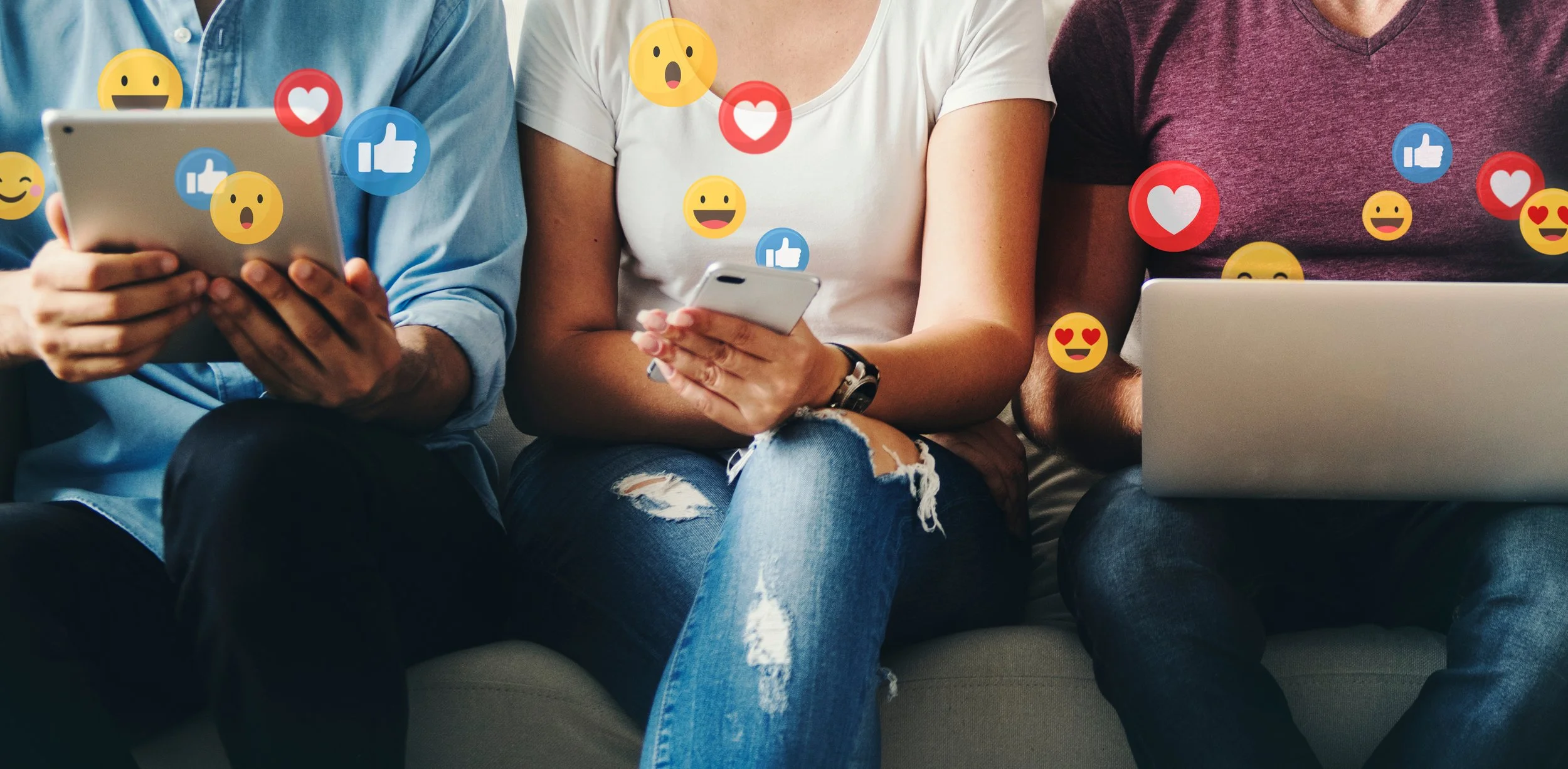 three people sitting on a couch on social media with different electronic devices and a bunch of emoji symbols to show interactions