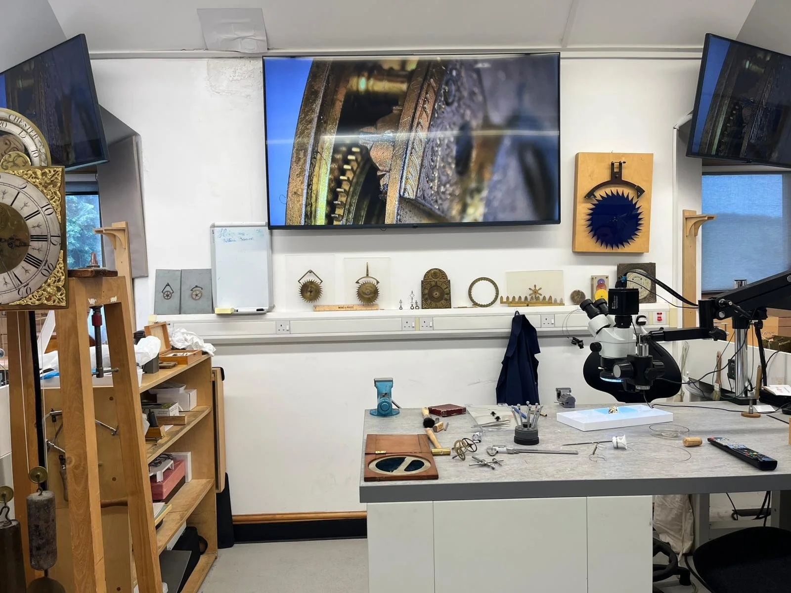 Art Laboratory with paints, sculptures, artistic workshop, tools, and clock parts on shelves and a worktable.