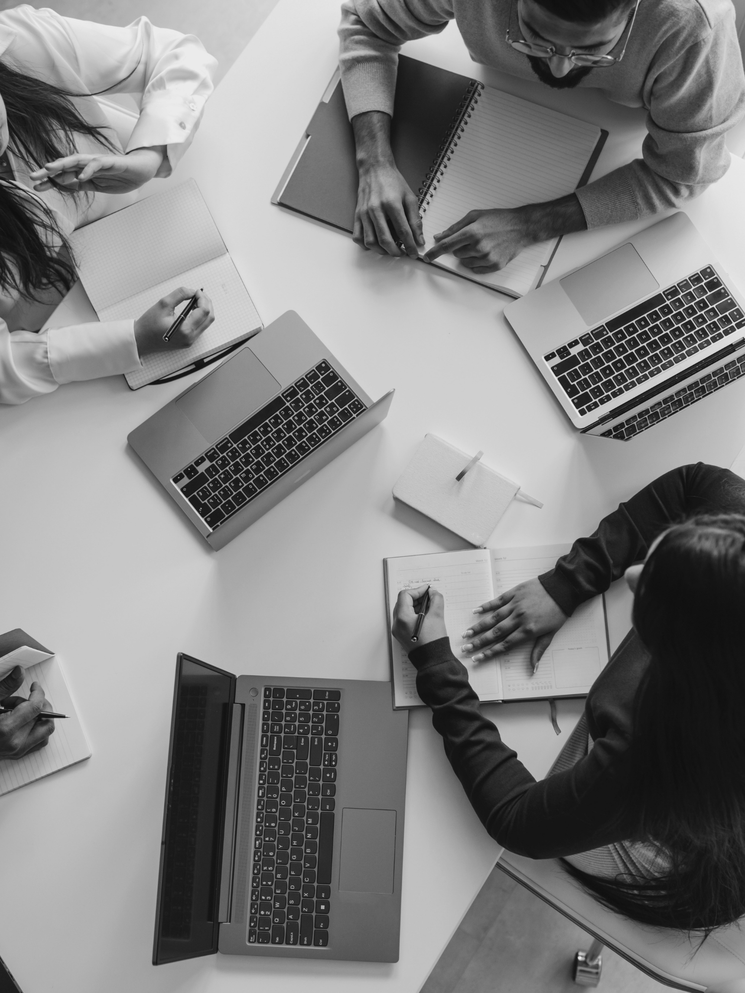 overhead shot of a team working at a table on computers
