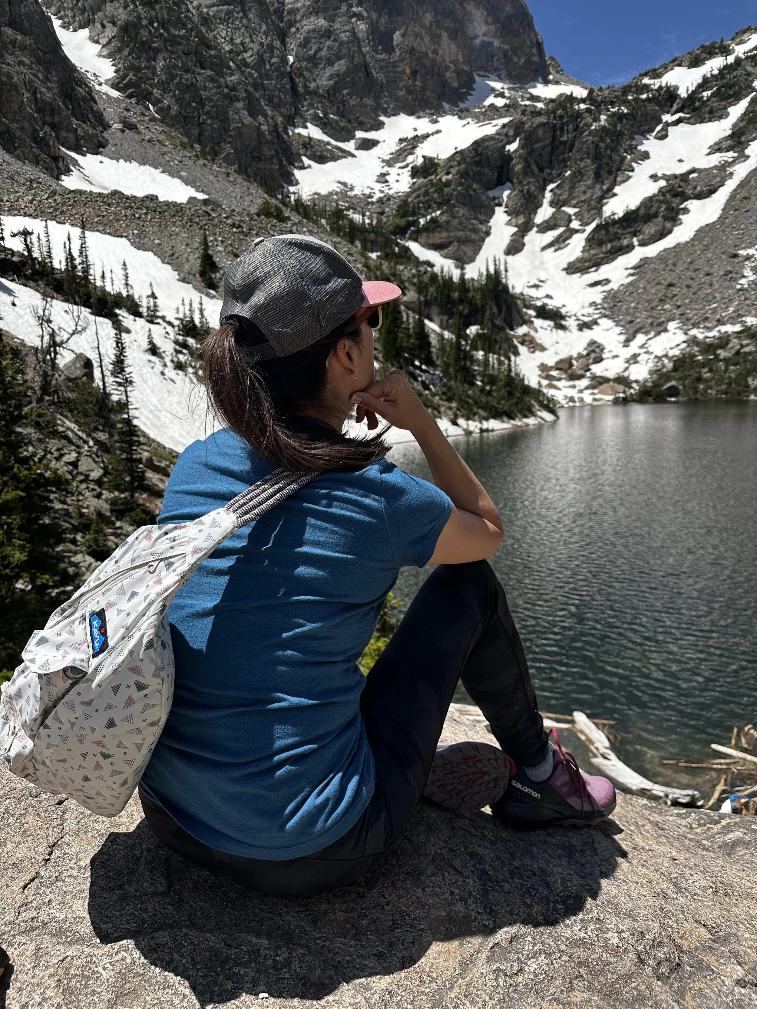 woman reflecting by a mountain lake during a life transition, seeking clarity and purpose after 40