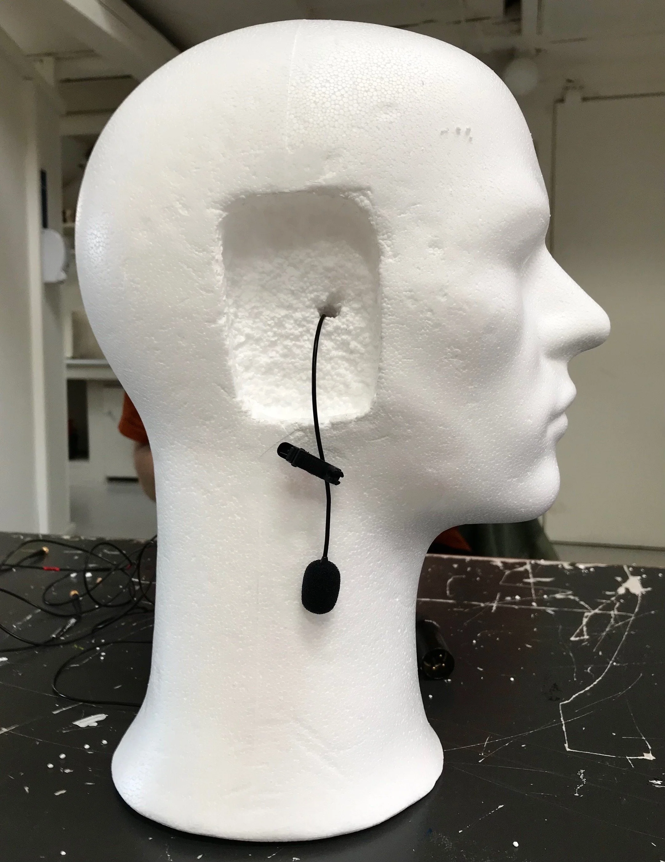 Et hvidt flamingohoved med en udskæring til øre, hvor der er påsat en mikrofon med ledning til binaurale optagelser | Kortfilm | Wild Wild Vesløs | Esben Persson | Filmproduktion Aarhus | GESTALT