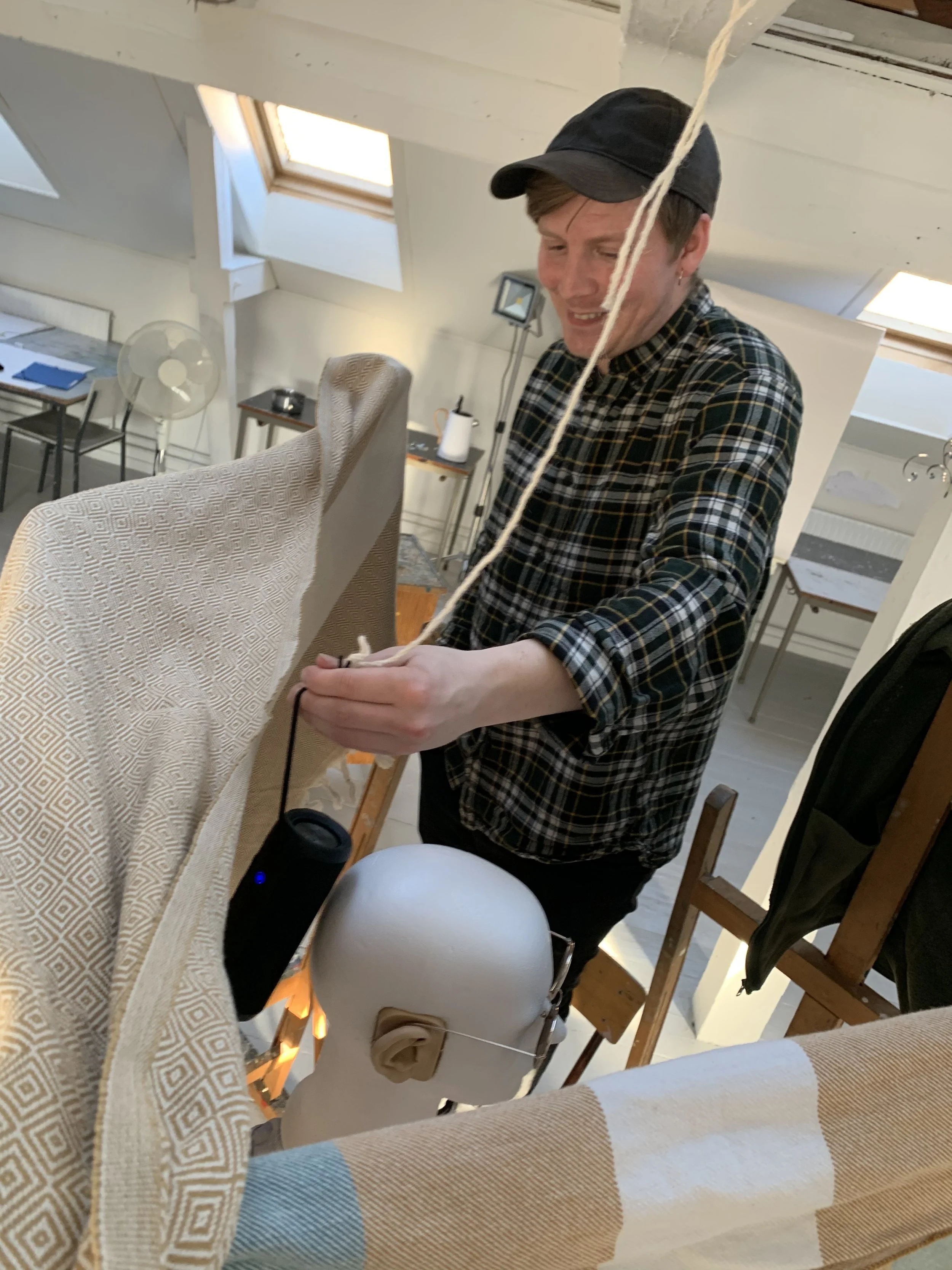 En mand arbejder i et lyst rum med et flamingohoved der har påmonteret mikrofoner | Lyddesign til kortfilm med binaural lyd | Filmproduktion Aarhus | GESTALT