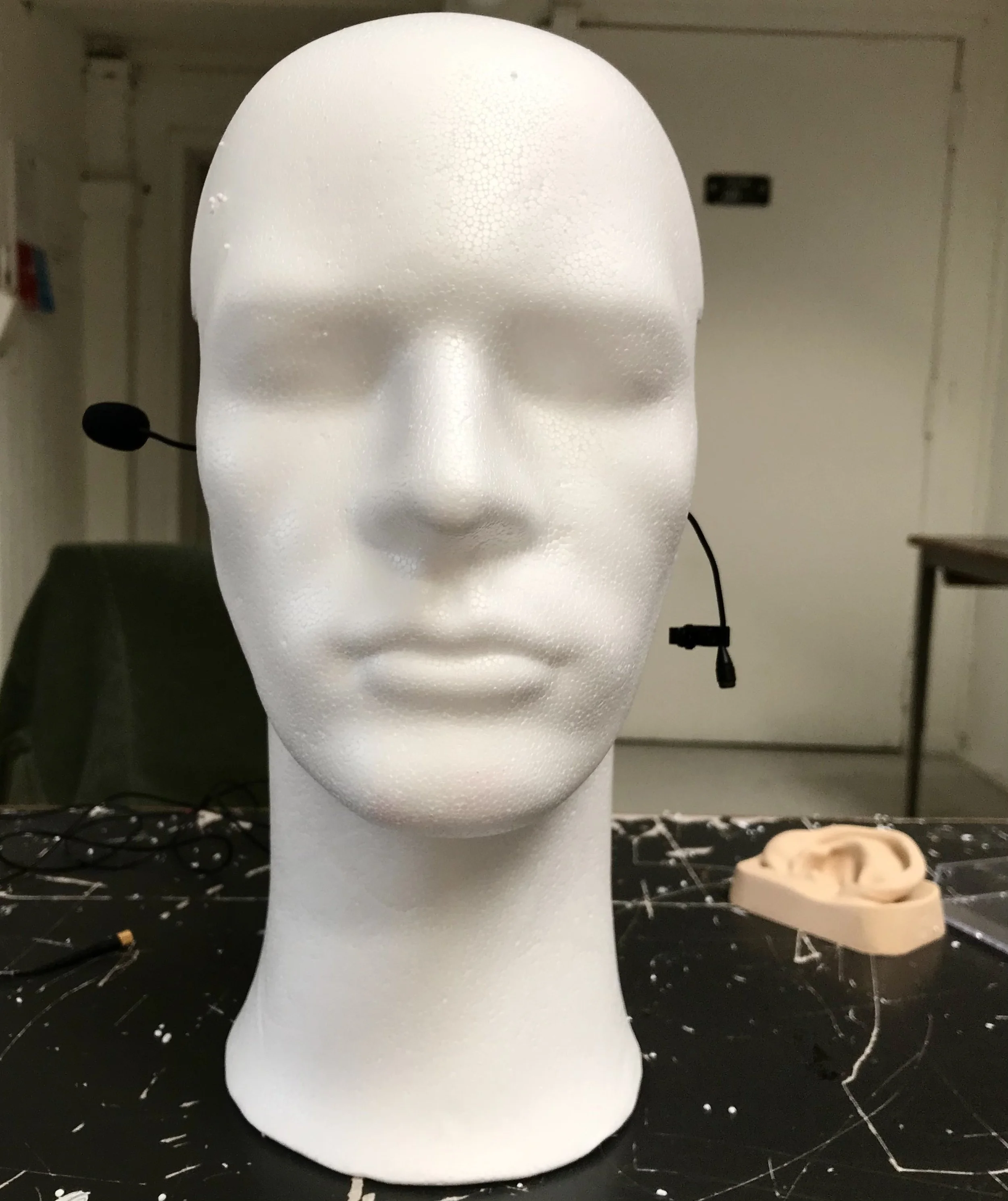 Et hvidt flamingohoved med en udskæring til øre, hvor der er påsat en mikrofon med ledning til binaurale optagelser | Kortfilm | Wild Wild Vesløs | Esben Persson | Filmproduktion Aarhus | GESTALT