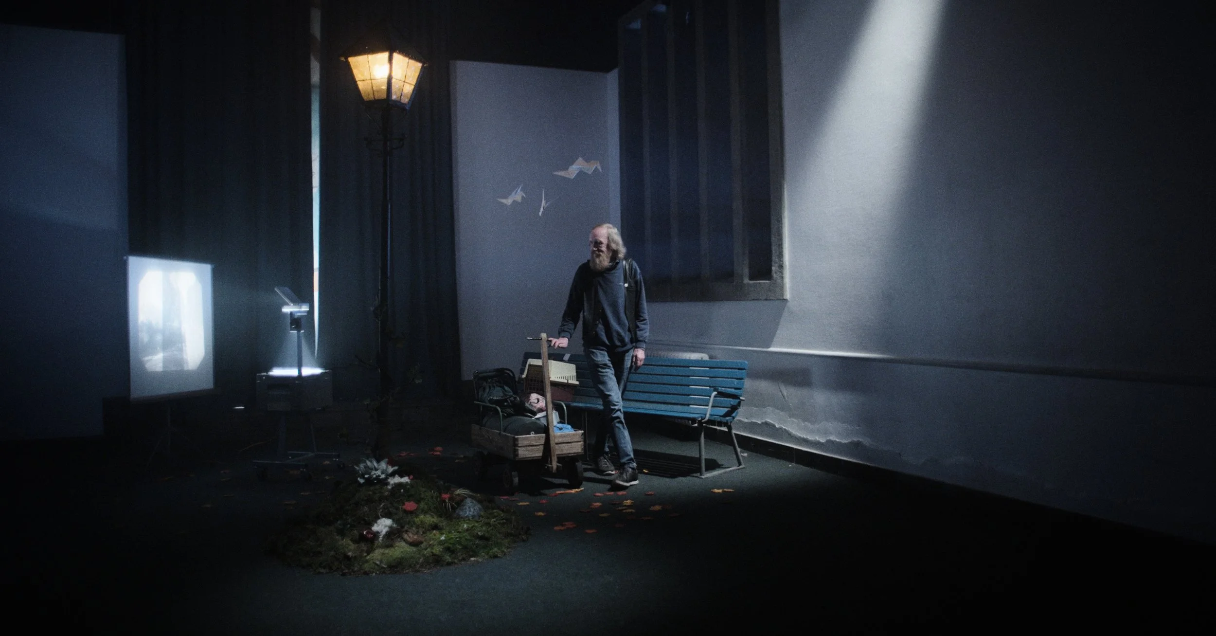 En mand med langt hvidt hår og skæg, der går i en mørkt, stille rum | Dokumentarfilm | Retrograd | Esben Persson & Anders Mielcke | Filmproduktion Aarhus | GESTALT