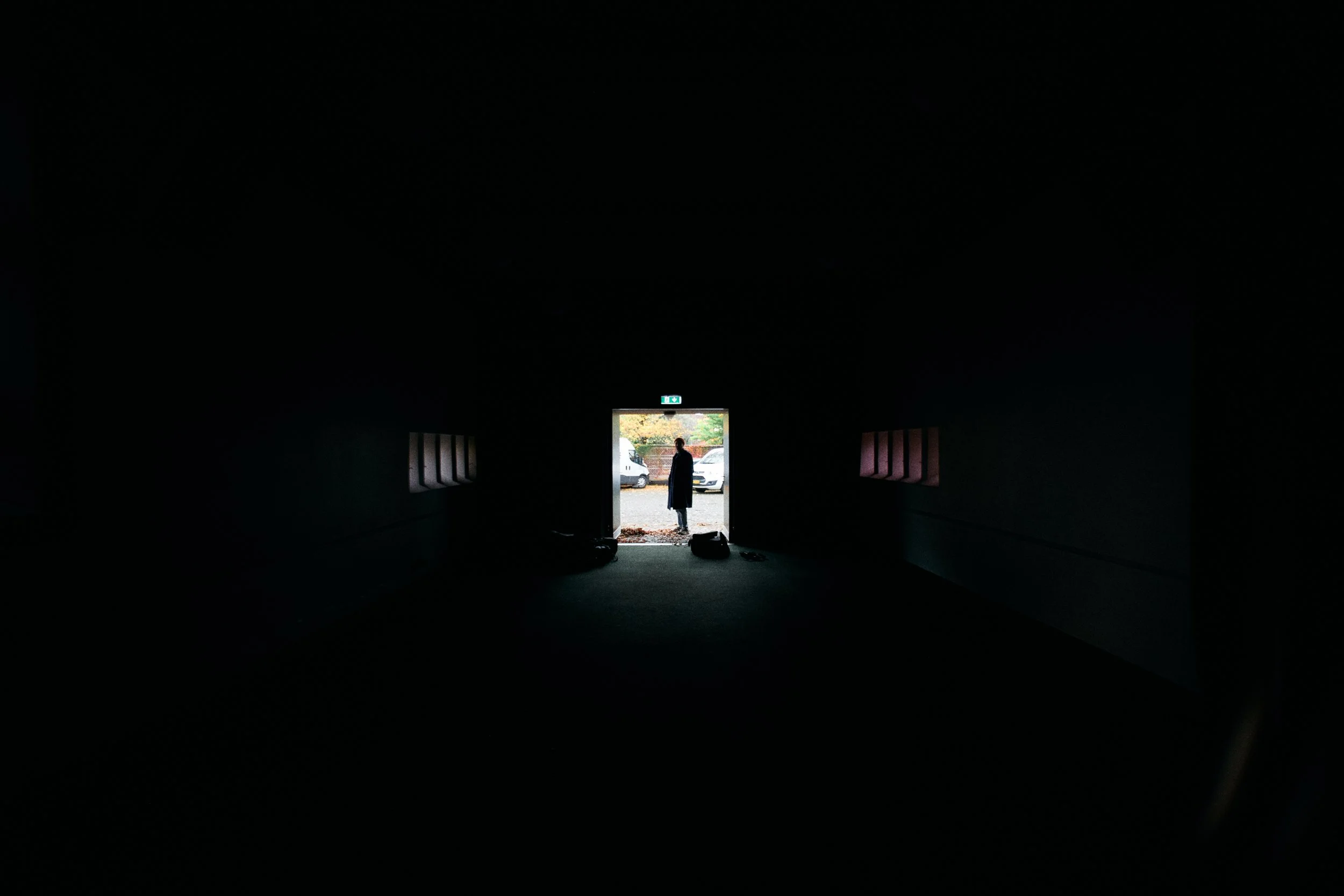 En person står foran en åben port, hvor der er nogle biler udenfor | Location scouting | Kodak | Filmproduktion Aarhus | GESTALT