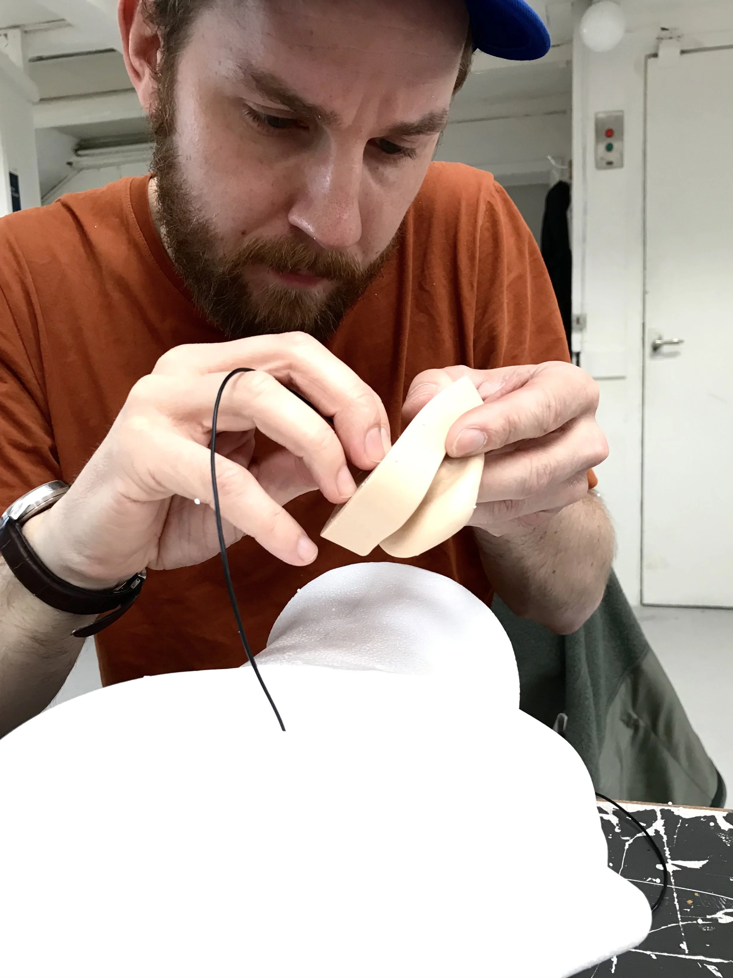 Et hvidt flamingohoved med en udskæring til øre, hvor der er påsat en mikrofon med ledning til binaurale optagelser | Kortfilm | Wild Wild Vesløs | Esben Persson | Filmproduktion Aarhus | GESTALT