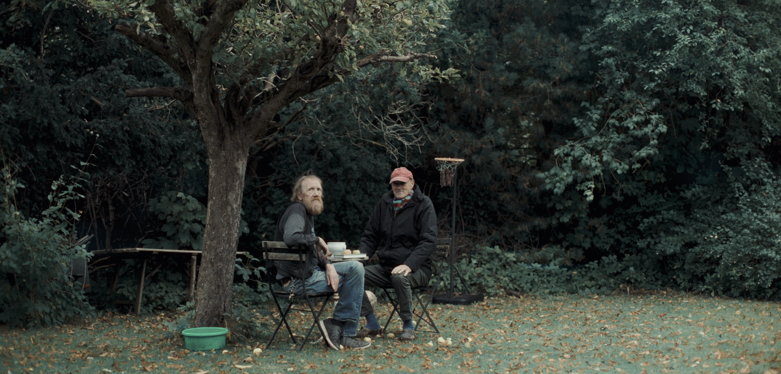 To mænd sidder ved et bord under et træ i en have på en efterårsdag | Dokumentarfilm | Retrograd | Esben Persson & Anders Mielcke | Filmproduktion Aarhus | GESTALT