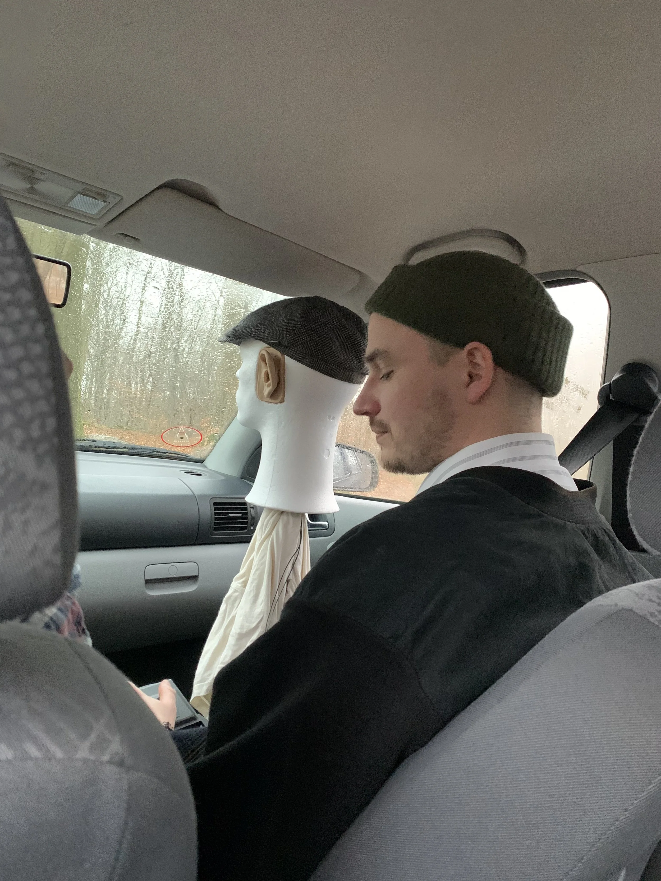 En mand sidder i en bil med et flamingohoved der har påmonteret mikrofoner | Lyddesign til kortfilm med binaural lyd | Filmproduktion Aarhus | GESTALT