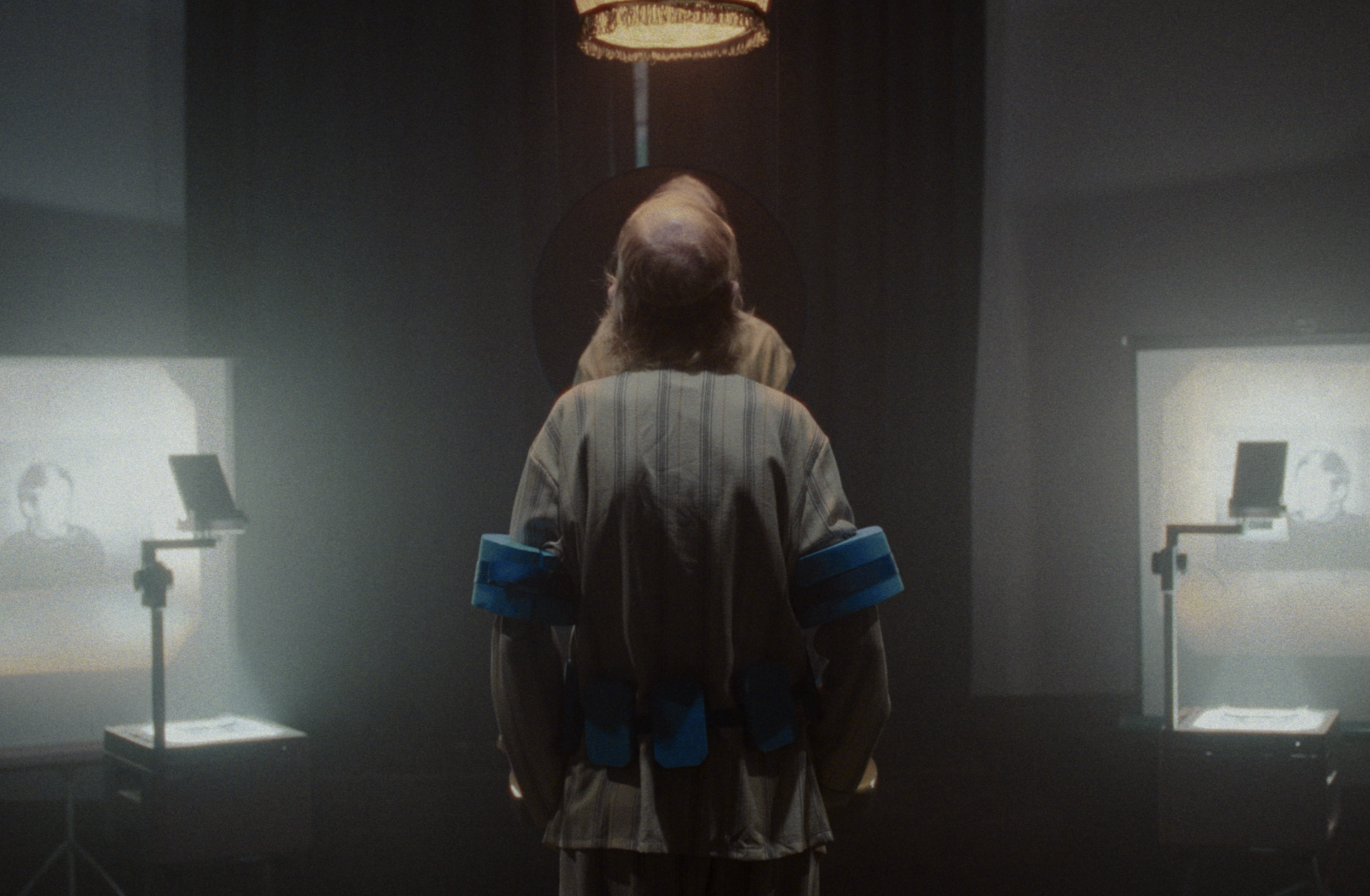 En person står foran to lærreder med sorte og hvide billeder med et barndomsbillede | Dokumentarfilm | Retrograd | Esben Persson & Anders Mielcke | Filmproduktion Aarhus | GESTALT