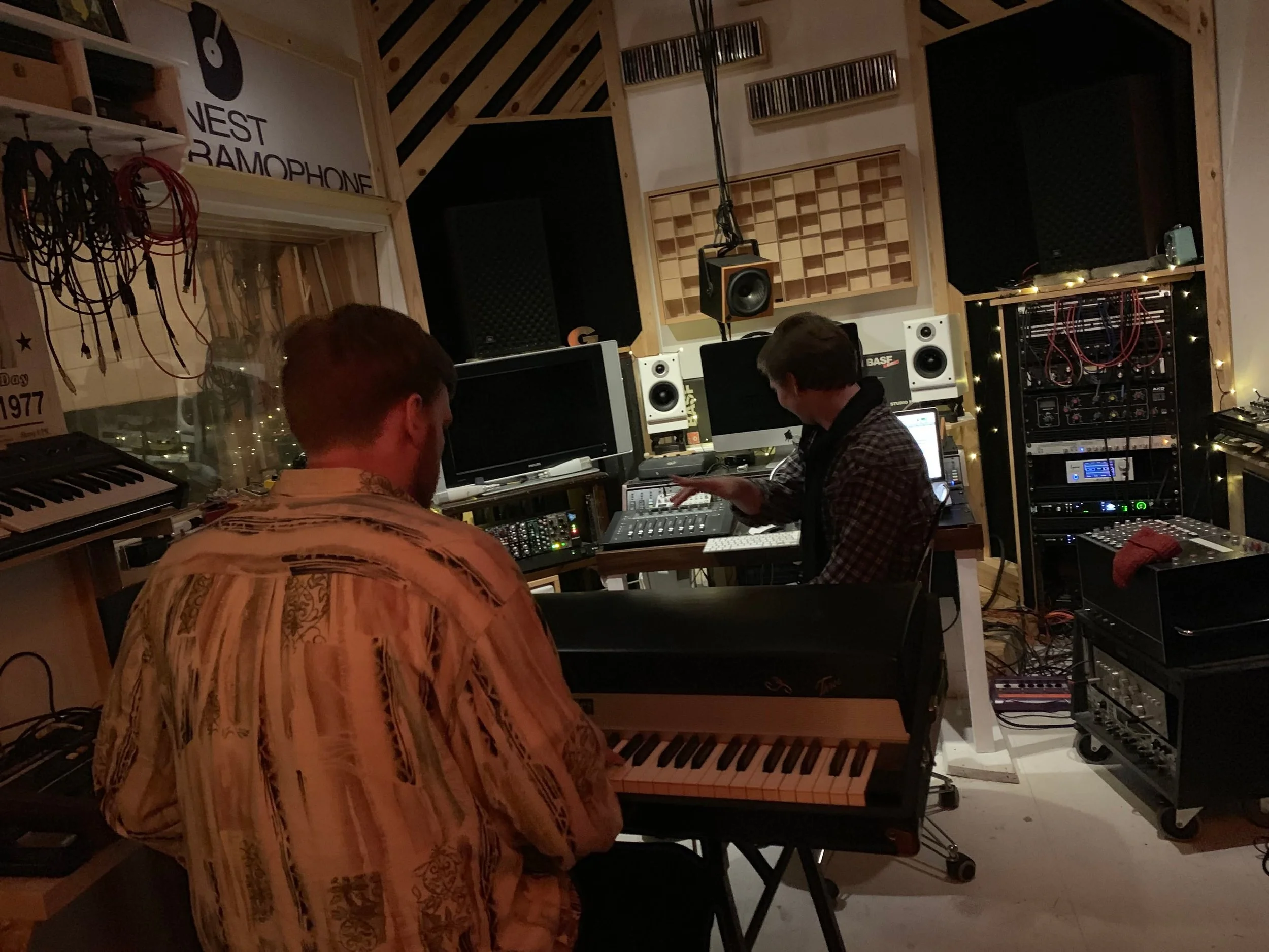 To personer arbejder i et musikstudie med instrumenter og lydudstyr | Musikkomposition | Studieproduktion og lyddesign | Filmproduktion Aarhus | GESTALT