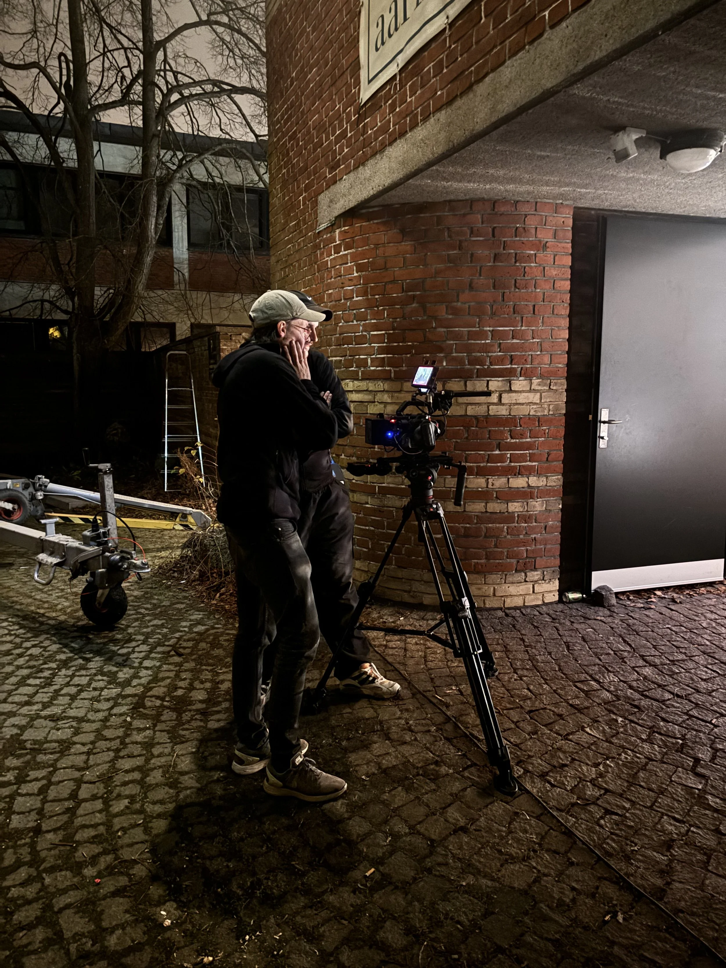 En mand står bag en kamerastativ med en kamera, mens han ser på en kameramonitor | Dokumentarfilm | Retrograd | Esben Persson & Anders Mielcke | Filmproduktion Aarhus | GESTALT