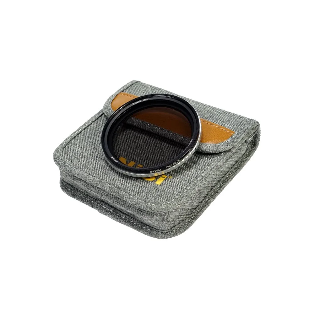 Et kameraobjektiv med filtrer på en grå stofpose.