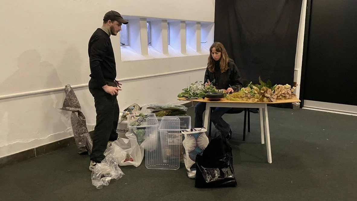 To personer, en mand og en kvinde, arbejder med blomster på et bord i et lokale | Dokumentarfilm | Retrograd | Esben Persson & Anders Mielcke  | Filmproduktion Aarhus | GESTALT