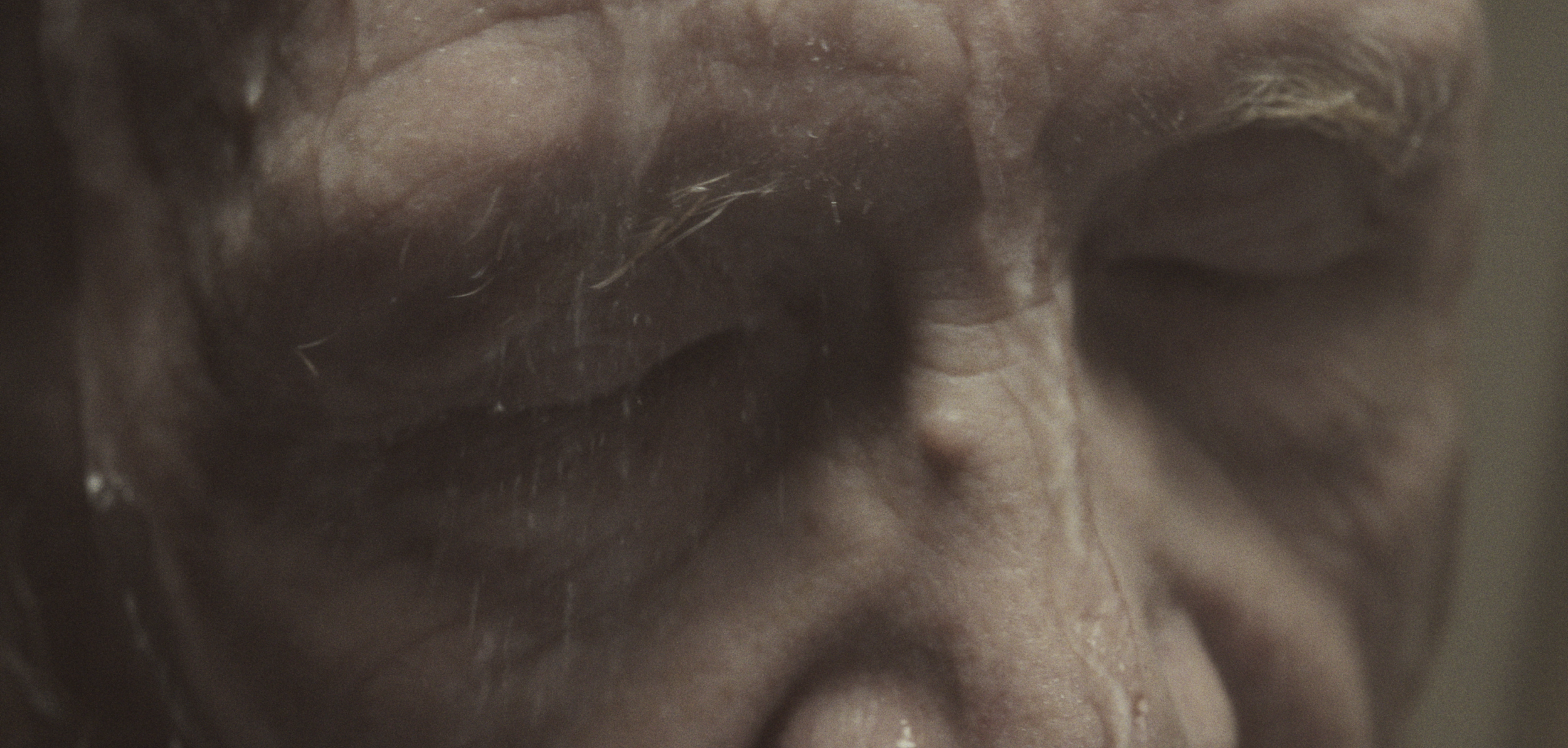Nærbillede af en persons ansigt, fokus på lukkede øjne og rynker ved øjenbrynene | Dokumentarfilm | Retrograd | Esben Persson & Anders Mielcke | Filmproduktion Aarhus | GESTALT