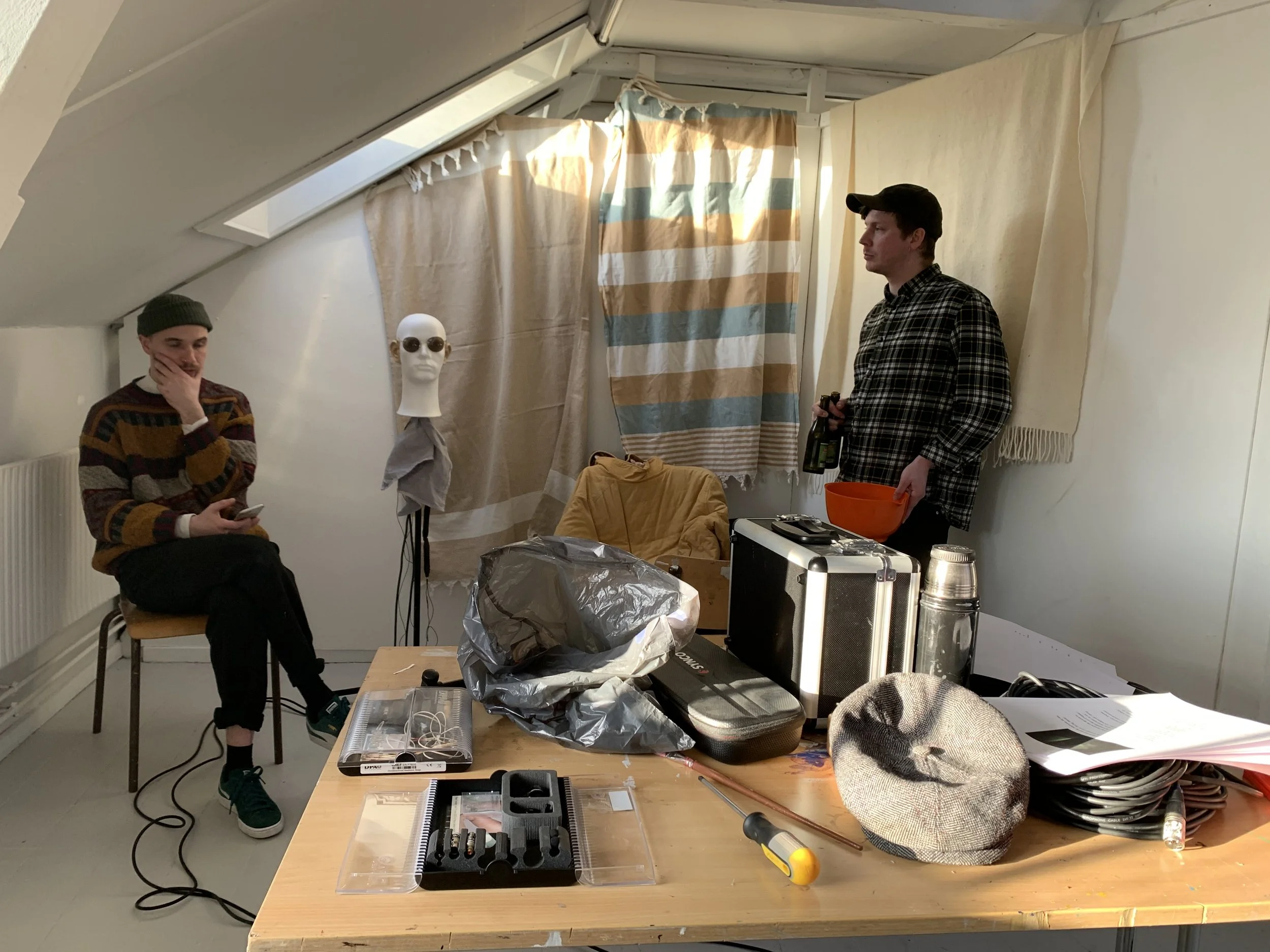 To mænd arbejder i et lyst rum med et flamingohoved der har påmonteret mikrofoner | Lyddesign til kortfilm med binaural lyd | Filmproduktion Aarhus | GESTALT