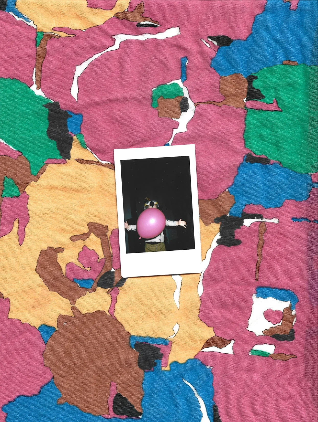 En farvet tæppe med abstrakte mønstre i grøn, blå, brun, pink, sort og hvid, med et Polaroidfoto liggende på tæppet | Stemningsbillede | Filmproduktion i Aarhus | GESTALT