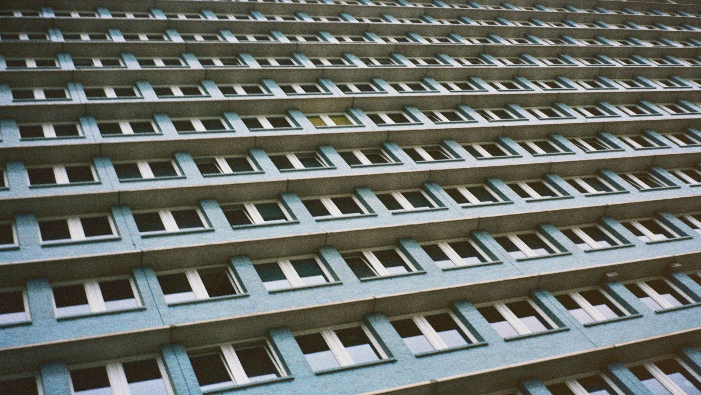 Et flere-etagers boligbyggeri med gentagne vinduer og balkonrækkefølger, taget set skråt ovenfra | Location scouting Berlin | Kodak | Filmproduktion Aarhus | GESTALT