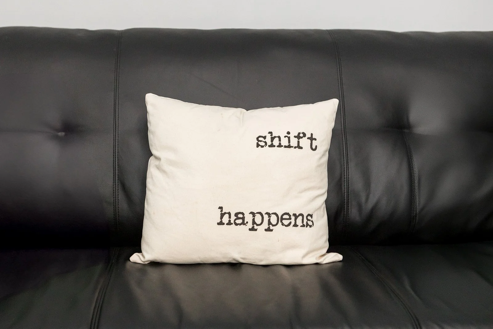 Woman with curly hair wearing a tank top, standing outdoors with arms outstretched and eyes closed, enjoying nature.